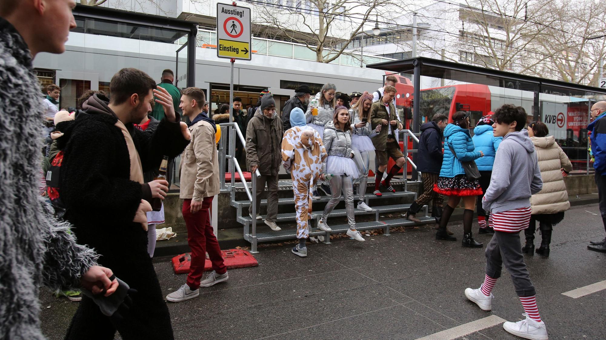 Jecke kommen an Weiberfastnacht an der Haltestelle Zülpicher Straße an.