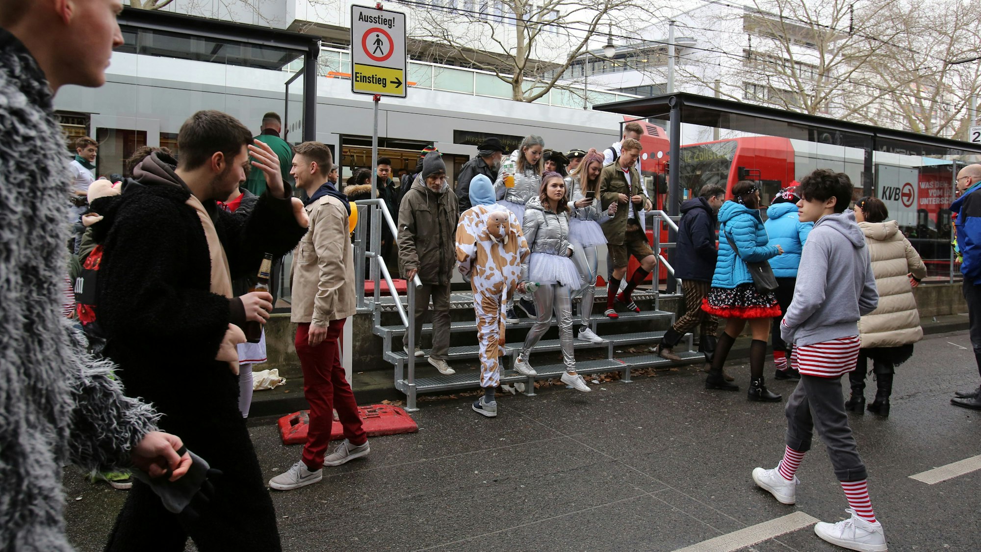 Jecke kommen an Weiberfastnacht an der Haltestelle Zülpicher Straße an.