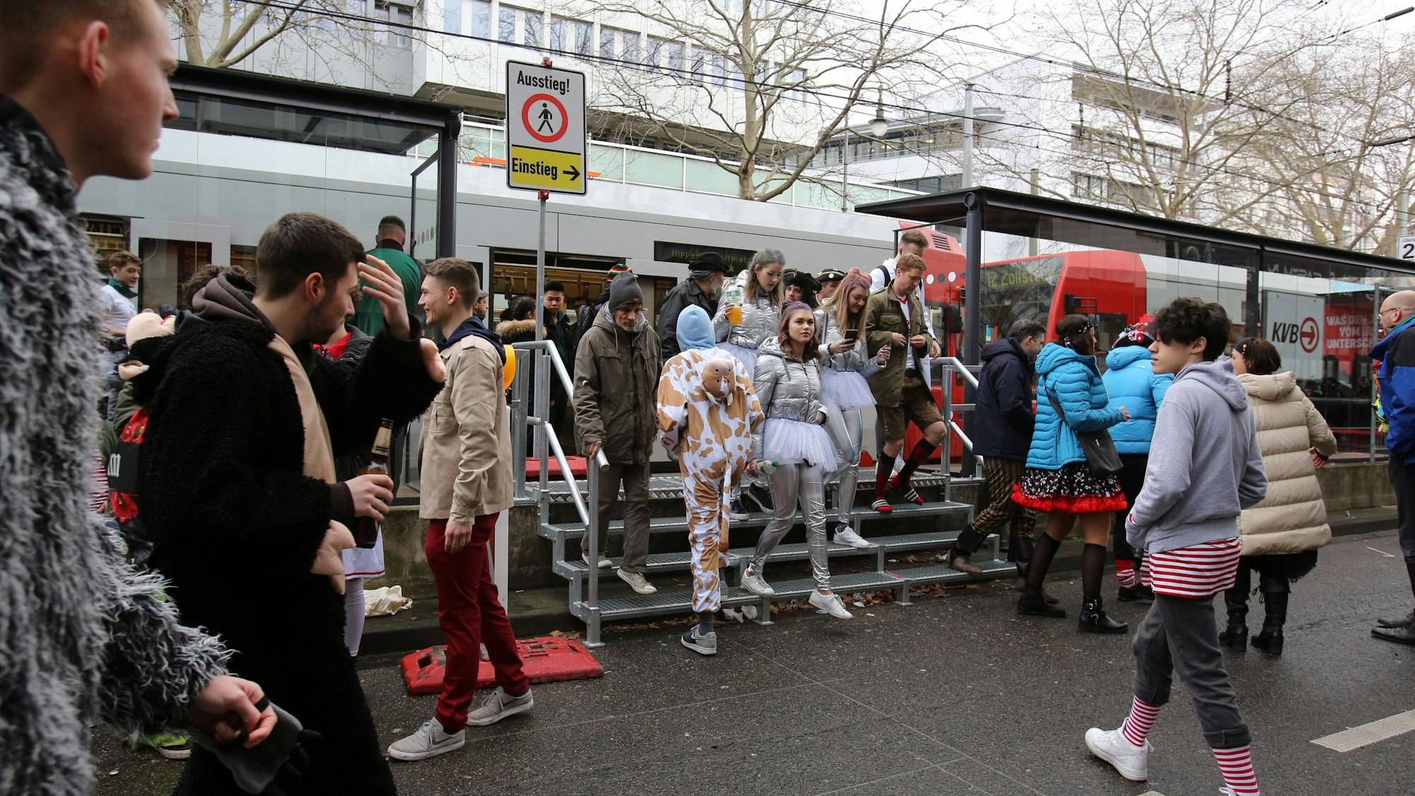 Jecke kommen an Weiberfastnacht an der Haltestelle Zülpicher Straße an.