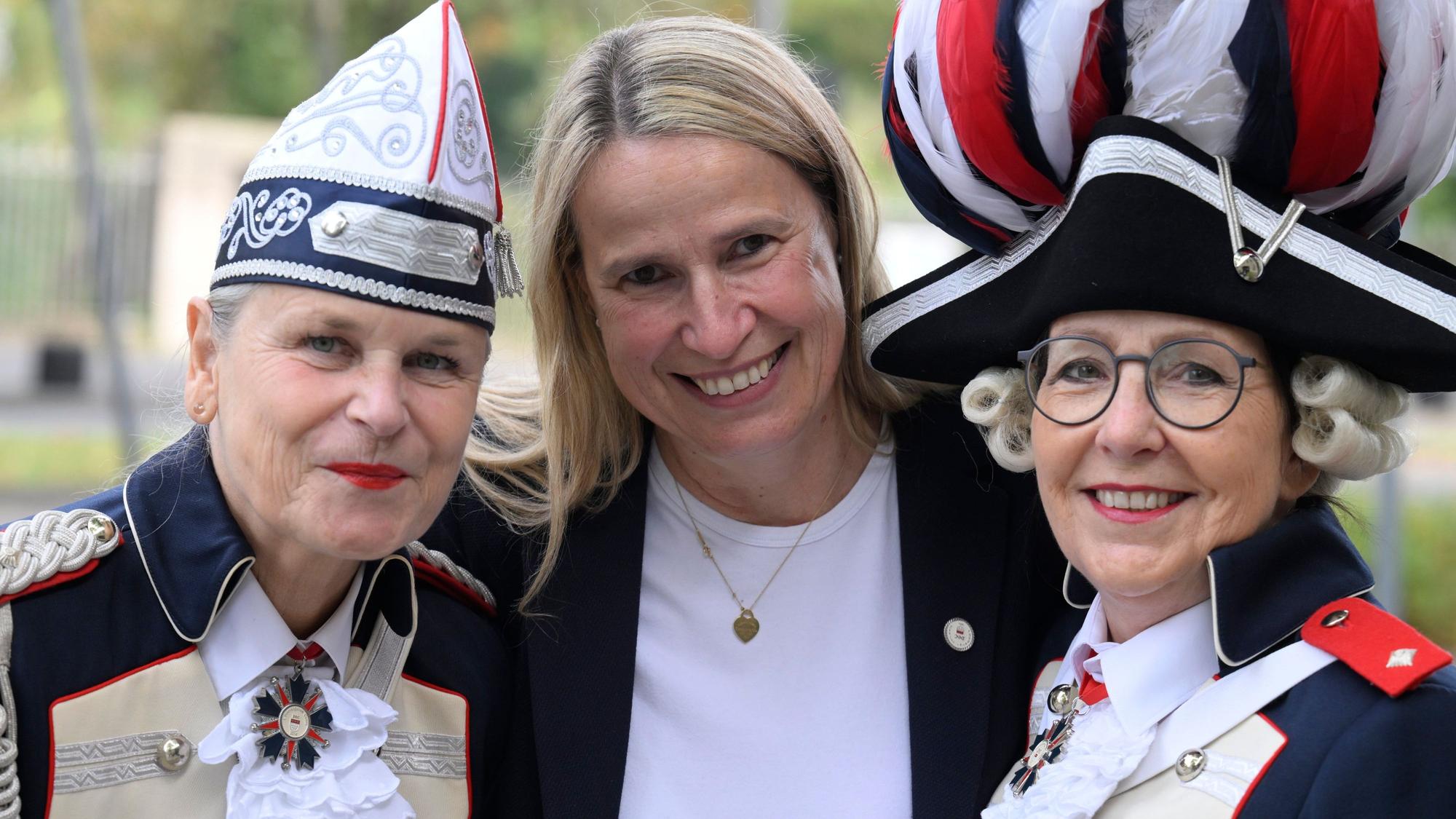 Die Karnevalistinnen Monika Kissing (l) und Bettina Schwerer (r) präsentieren zusammen mit der Präsidentin der „Ersten Damengarde Coeln 2014 e.V.“, Barbara Brüninghaus (M), ihre Karnevalskostüme in Form einer französischen Uniform.