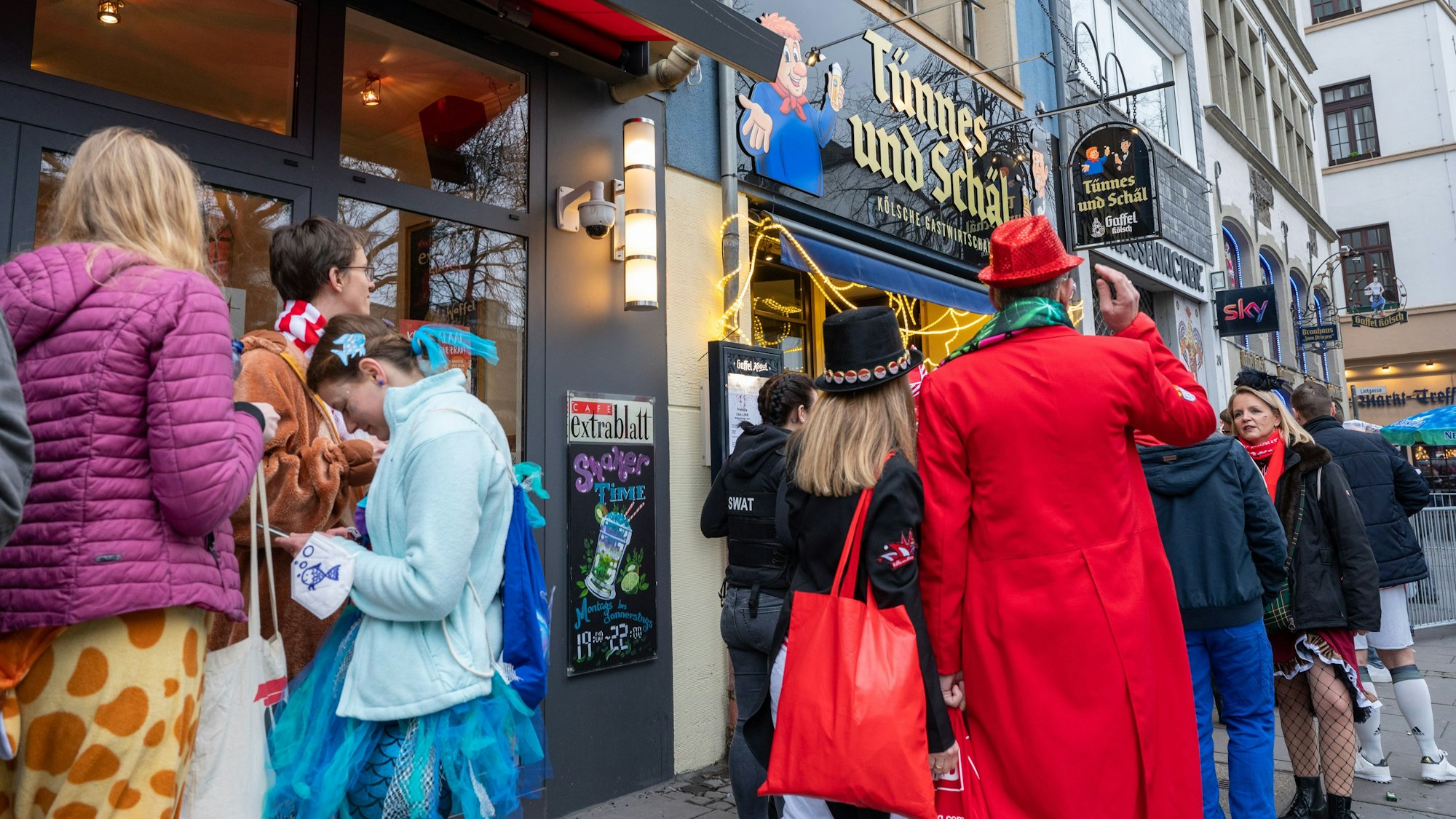 Warteschlange vor einer Kneipe in der Altstadt an Weiberfastnacht.