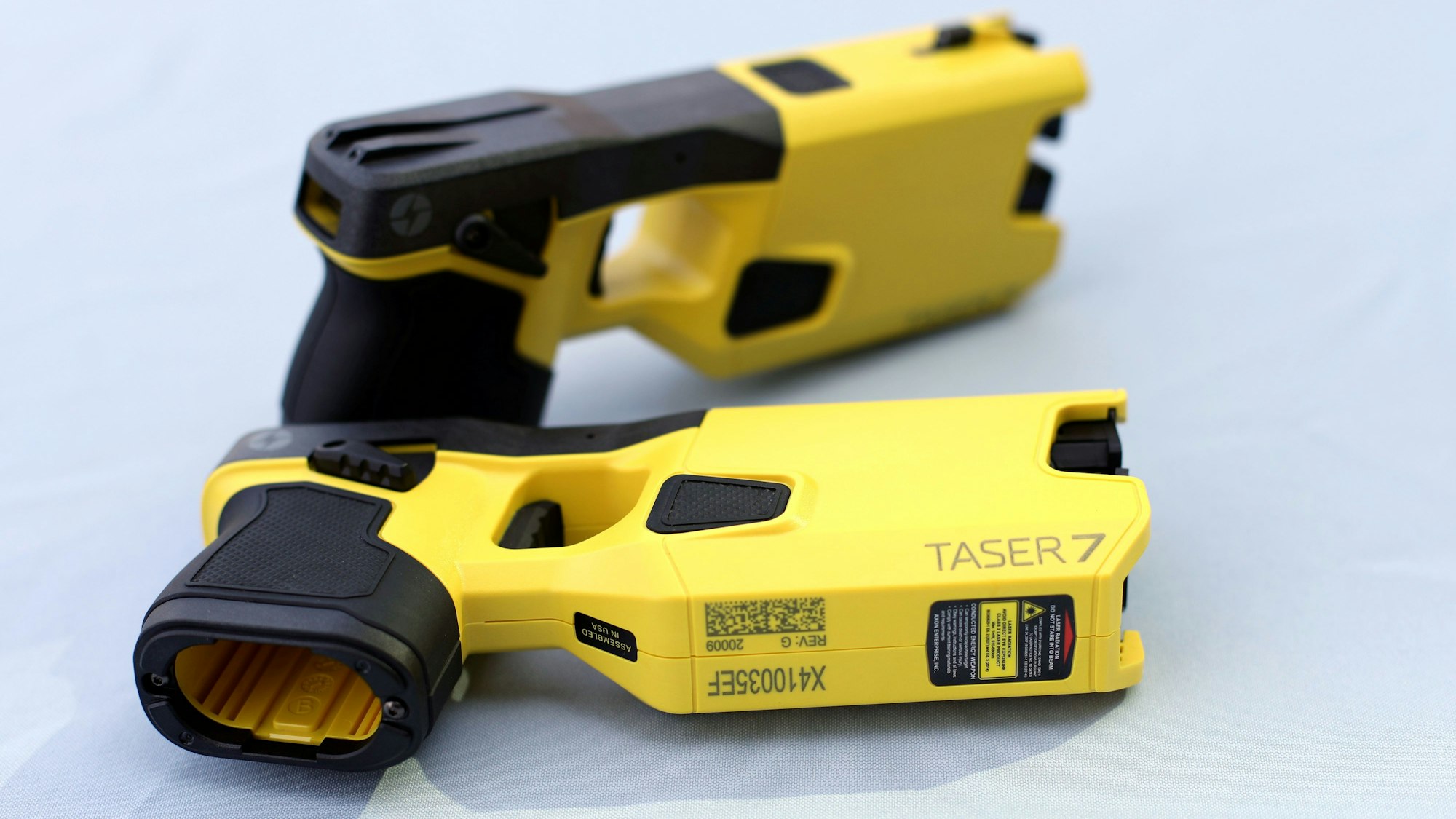 Zwei Elektroschockpistolen vom Typ „Taser 7“ liegen auf einem Tisch.