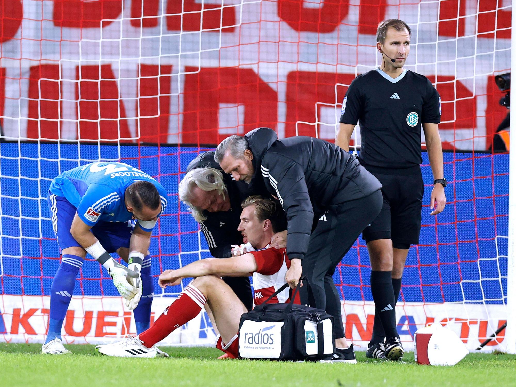Fortuna Düsseldorfs Stürmer Vincent Vermeij wird auf dem Platz von Teamarzt Ulf Blecker versorgt.