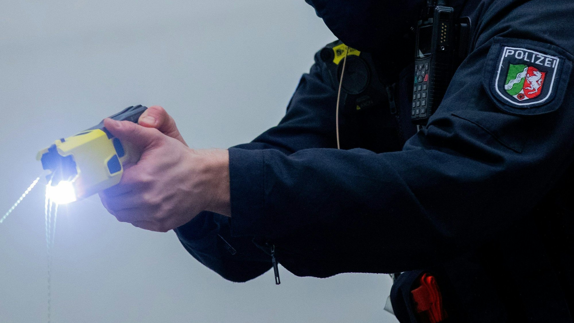 Ein Polizeibeamter demonstriert einen Schuss mit einem Distanzelektroimpulsgerät (DEIG oder auch Taser).