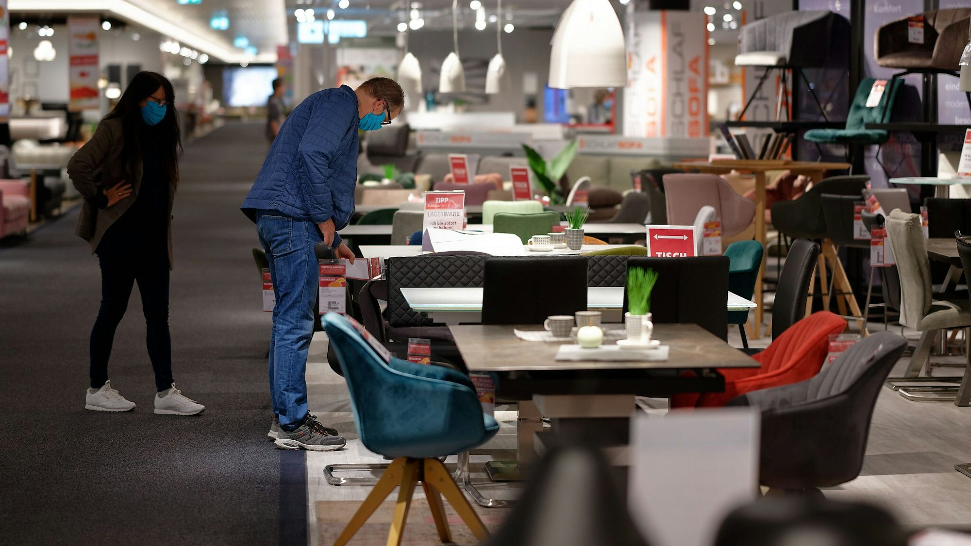 Kunden betrachten im Möbelhaus Segmüller Möbel.