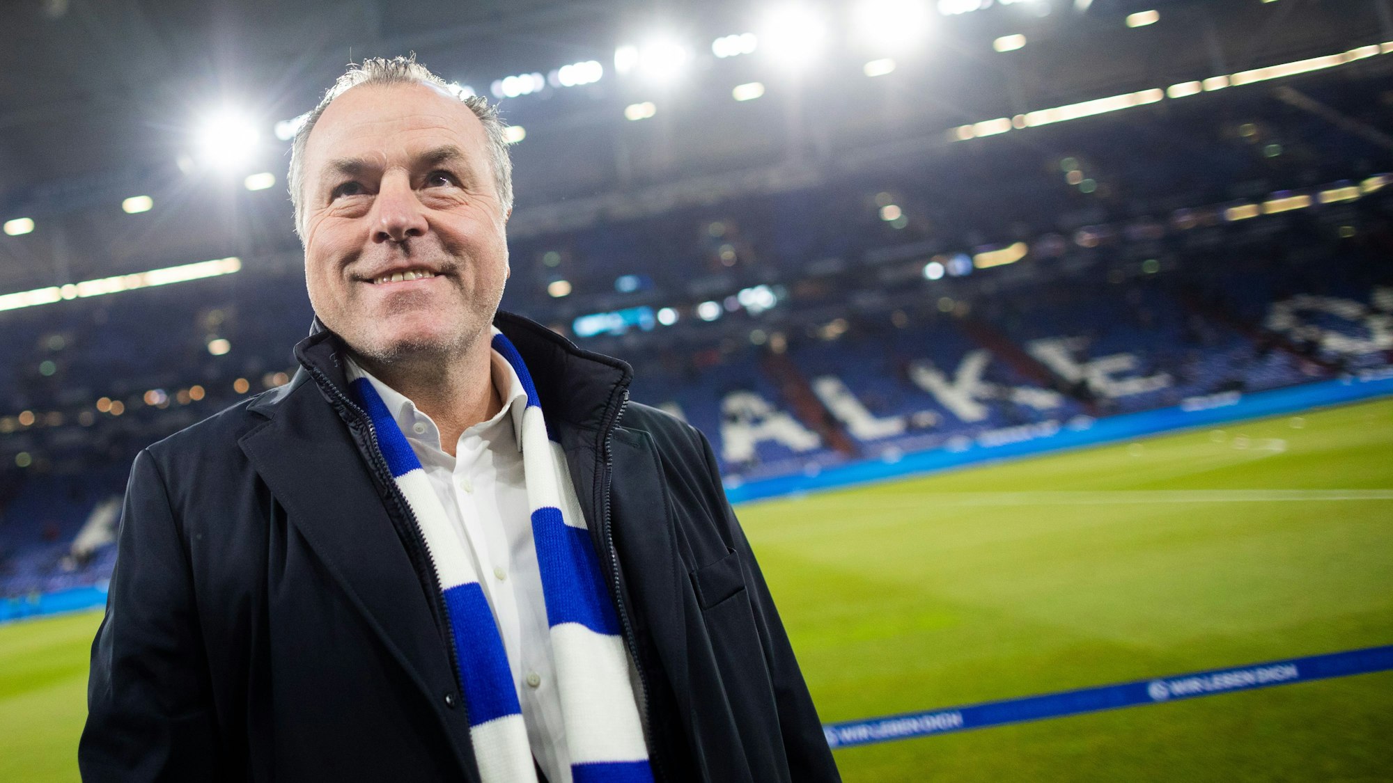 Clemens Tönnies steht mit blau-weißem Schal im Schalke-Stadion.