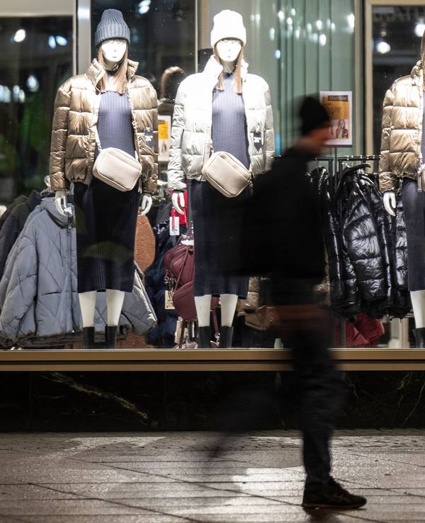 Ein Passant läuft vor einem Schaufenster eines Bekleidungsgeschäfts entlang.