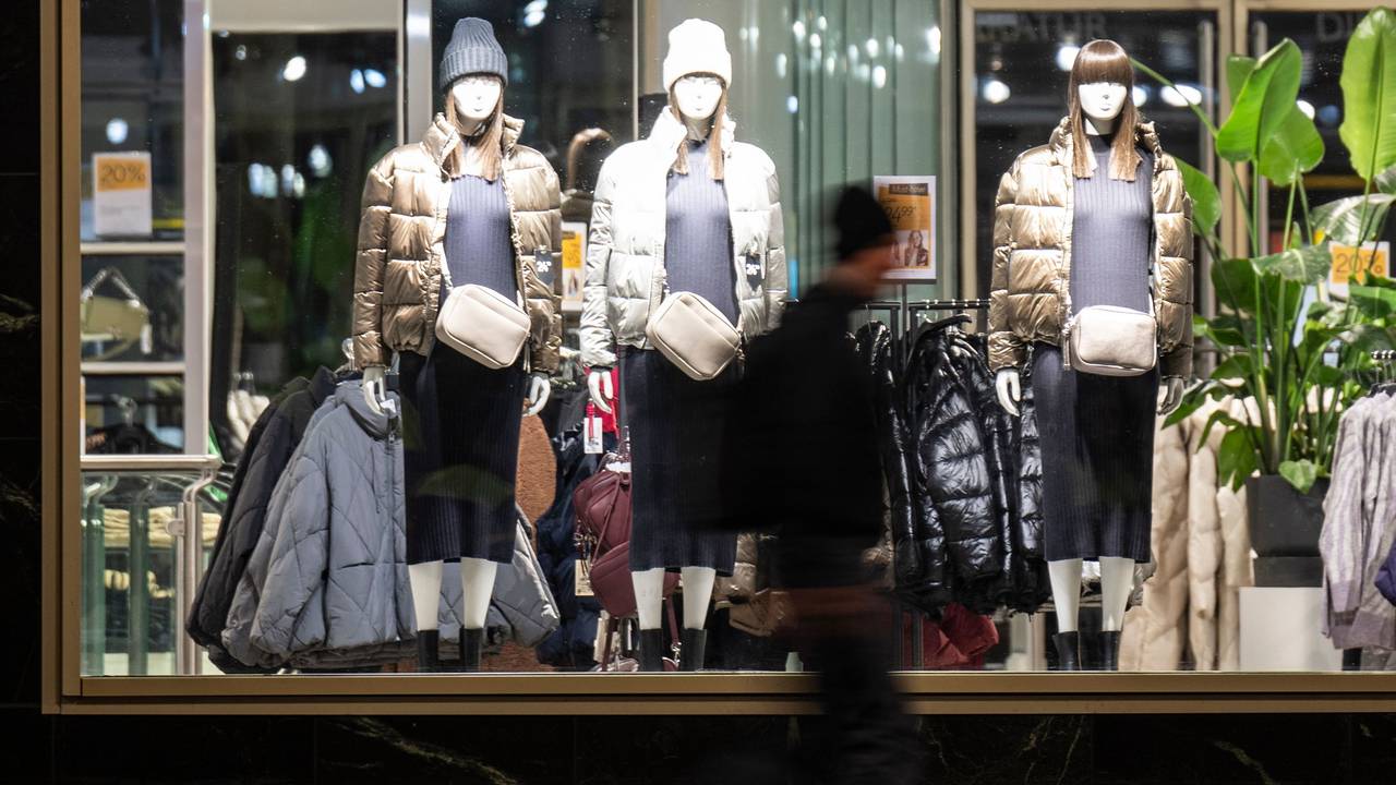 Ein Passant läuft vor einem Schaufenster eines Bekleidungsgeschäfts entlang.