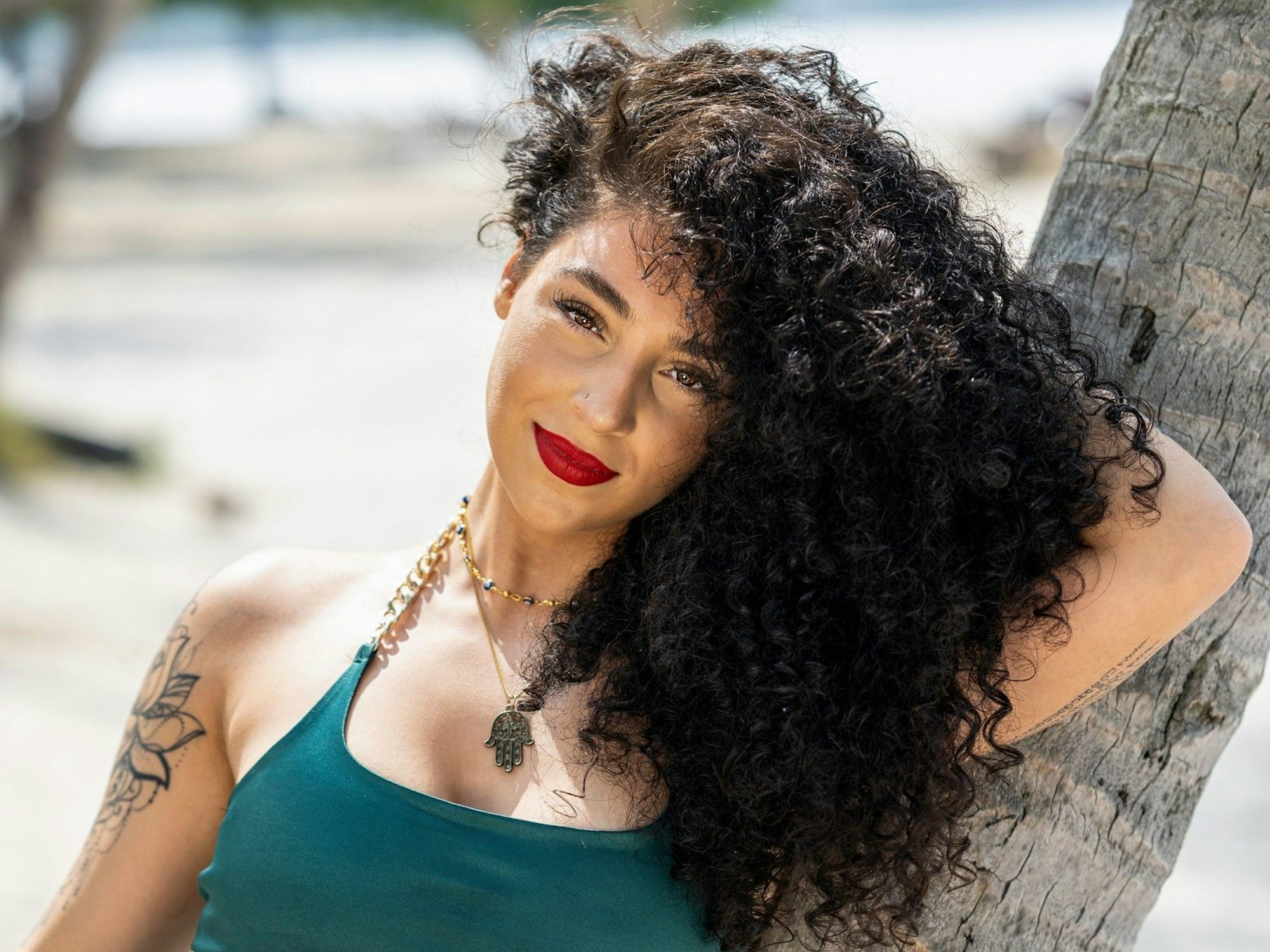 Aleyna lehnt sich an einen Baum.