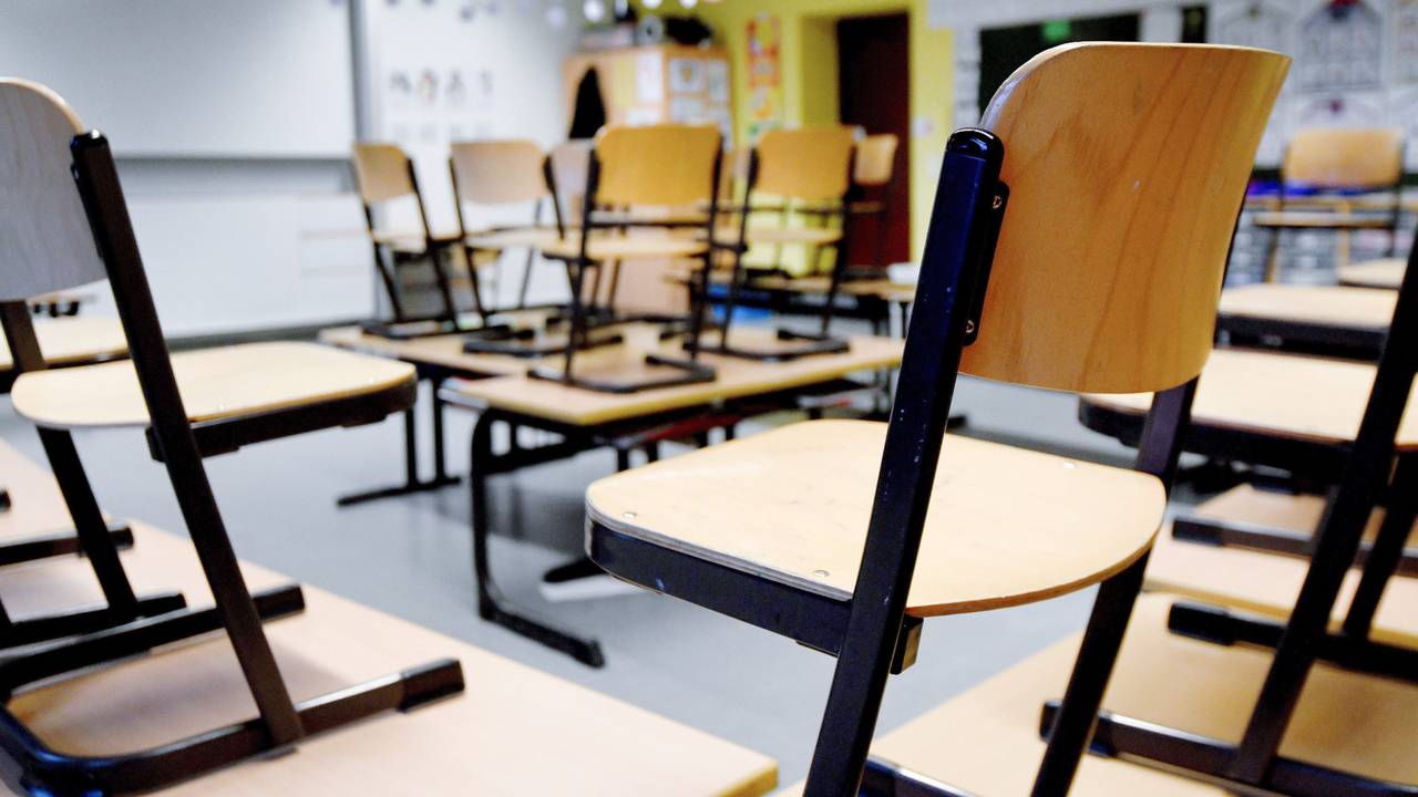 Stühle stehen in einem Klassenzimmer in einer Grundschule auf den Tischen.