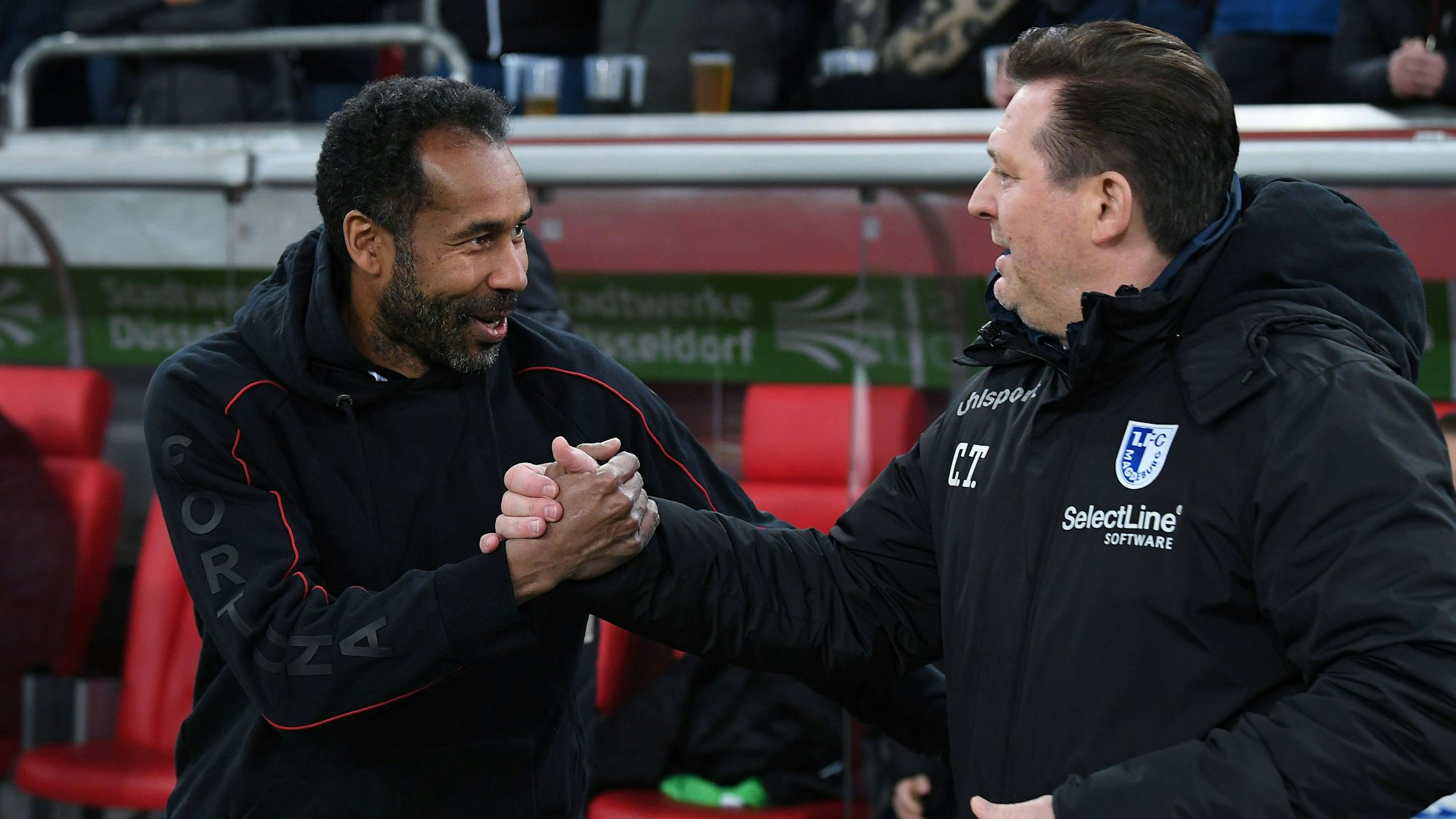 Daniel Thioune und Christian Titz begrüßen sich vor dem Spiel per Handschlag.