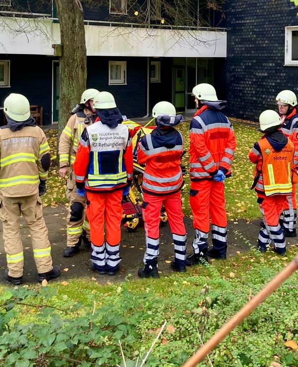 Feuerwehrleute stehen vor einem Gebäude.