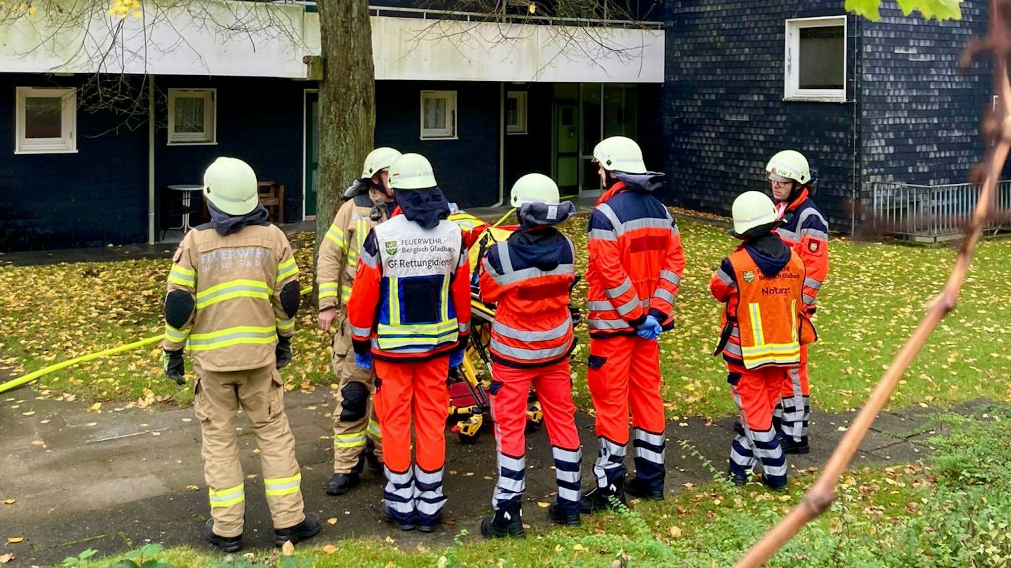 Feuerwehrleute stehen vor einem Gebäude.