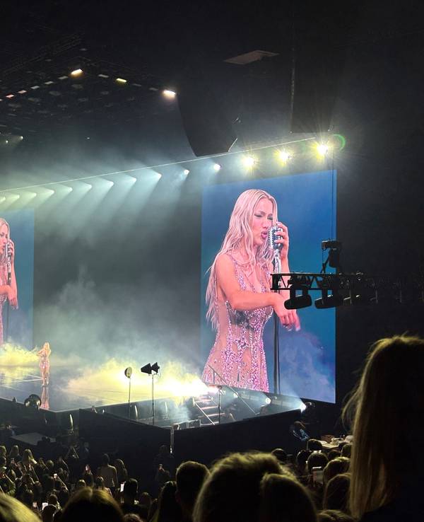 Shirin David steht auf der Bühne und singt in ein Old-School-Mikrofon.