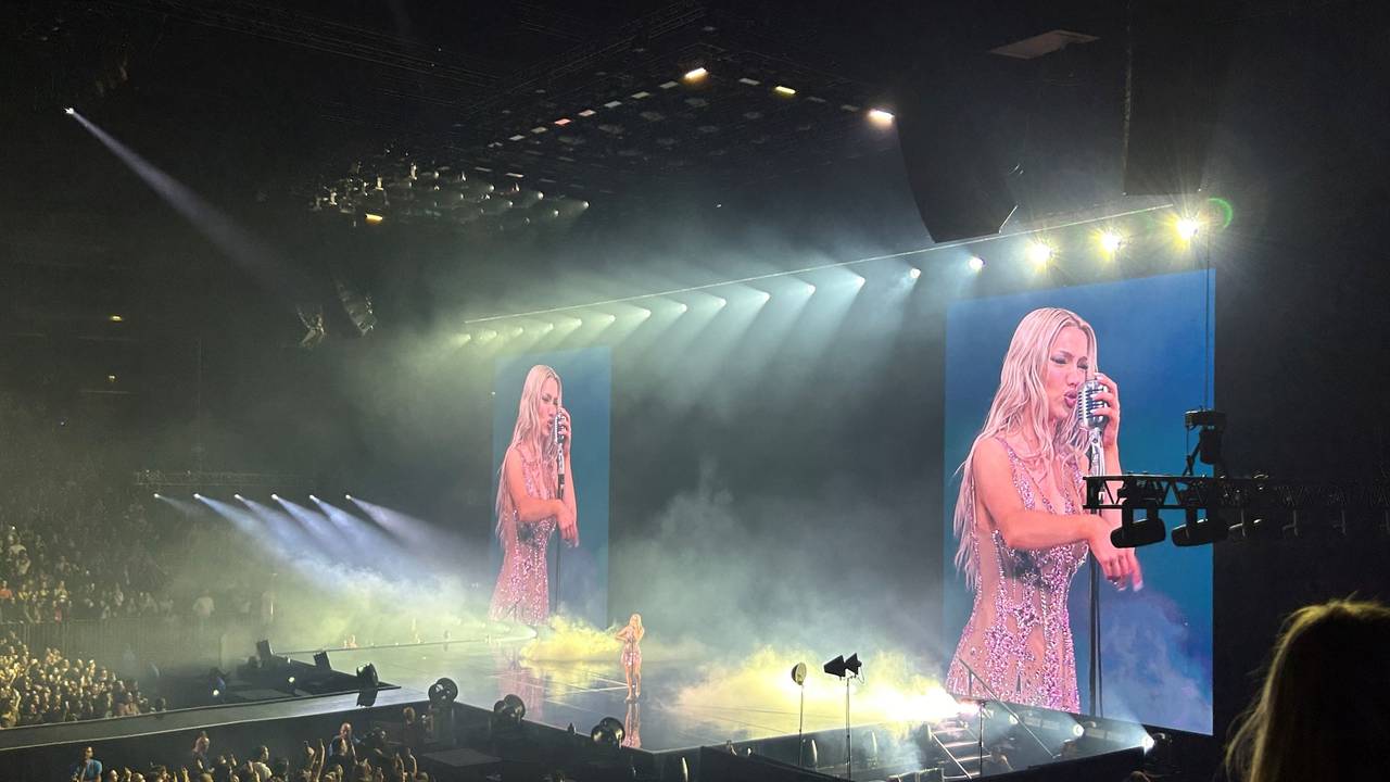 Shirin David steht auf der Bühne und singt in ein Old-School-Mikrofon.