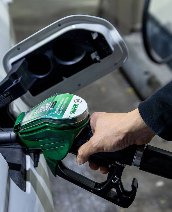 Ein Autofahrer tankt ein Auto mit Benzin Super E5 an einer Tankstelle.