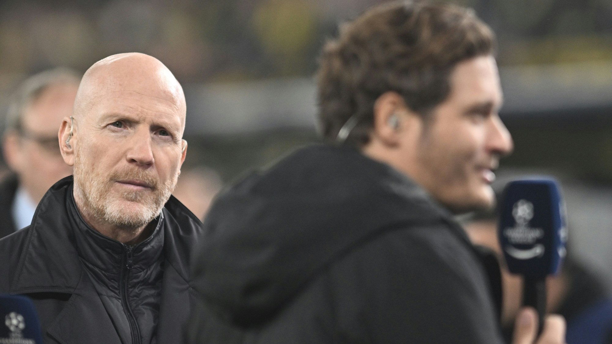 Dortmunds externer Berater Matthias Sammer (l) hört Trainer Edin Terzic vor dem Spiel am Mikrofon zu.