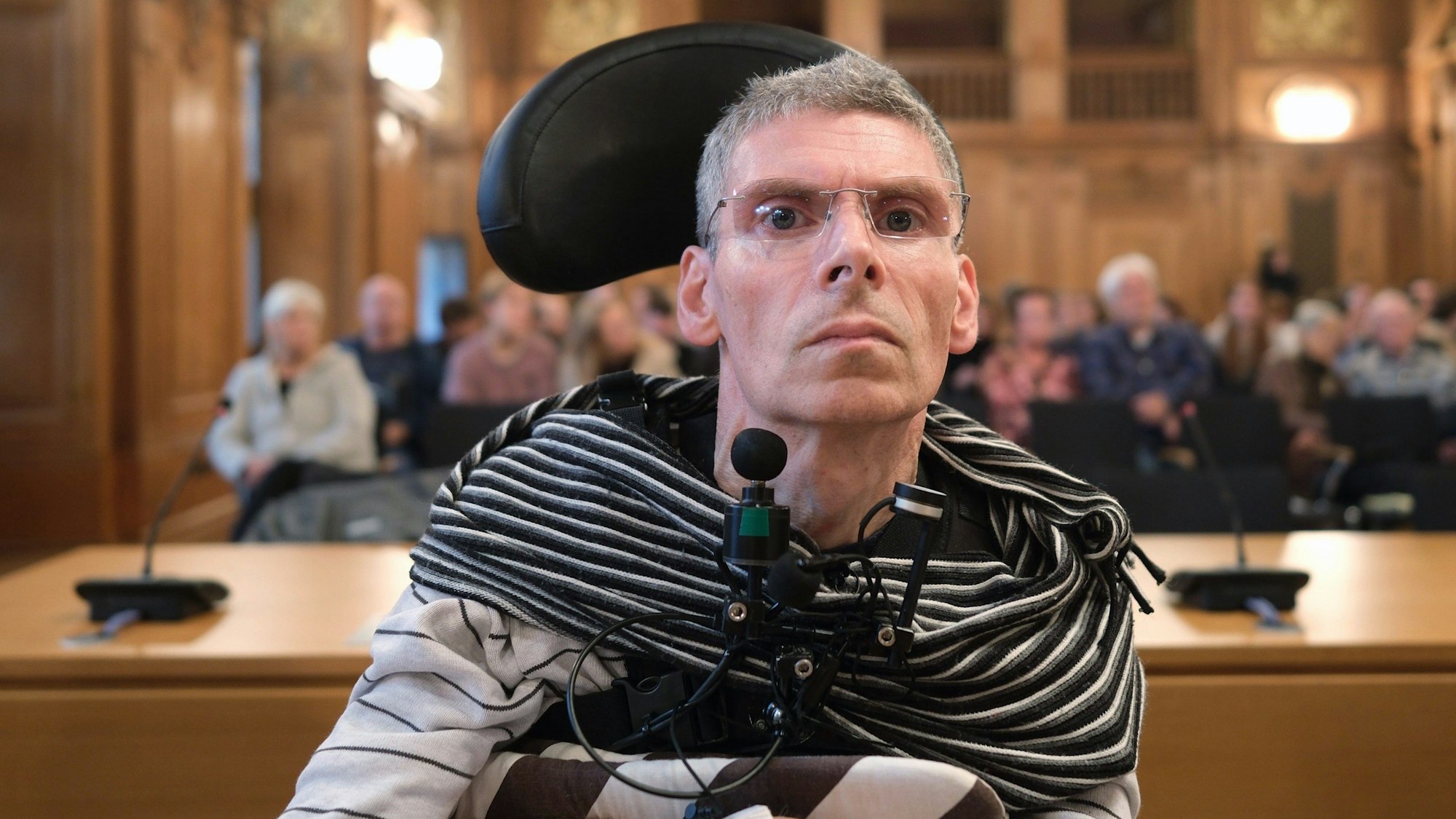 Harald Mayer, durch Multiple Sklerose komplett bewegungsunfähig, sitzt in einem Saal des Bundesverwaltungsgerichtes (BVerwG).