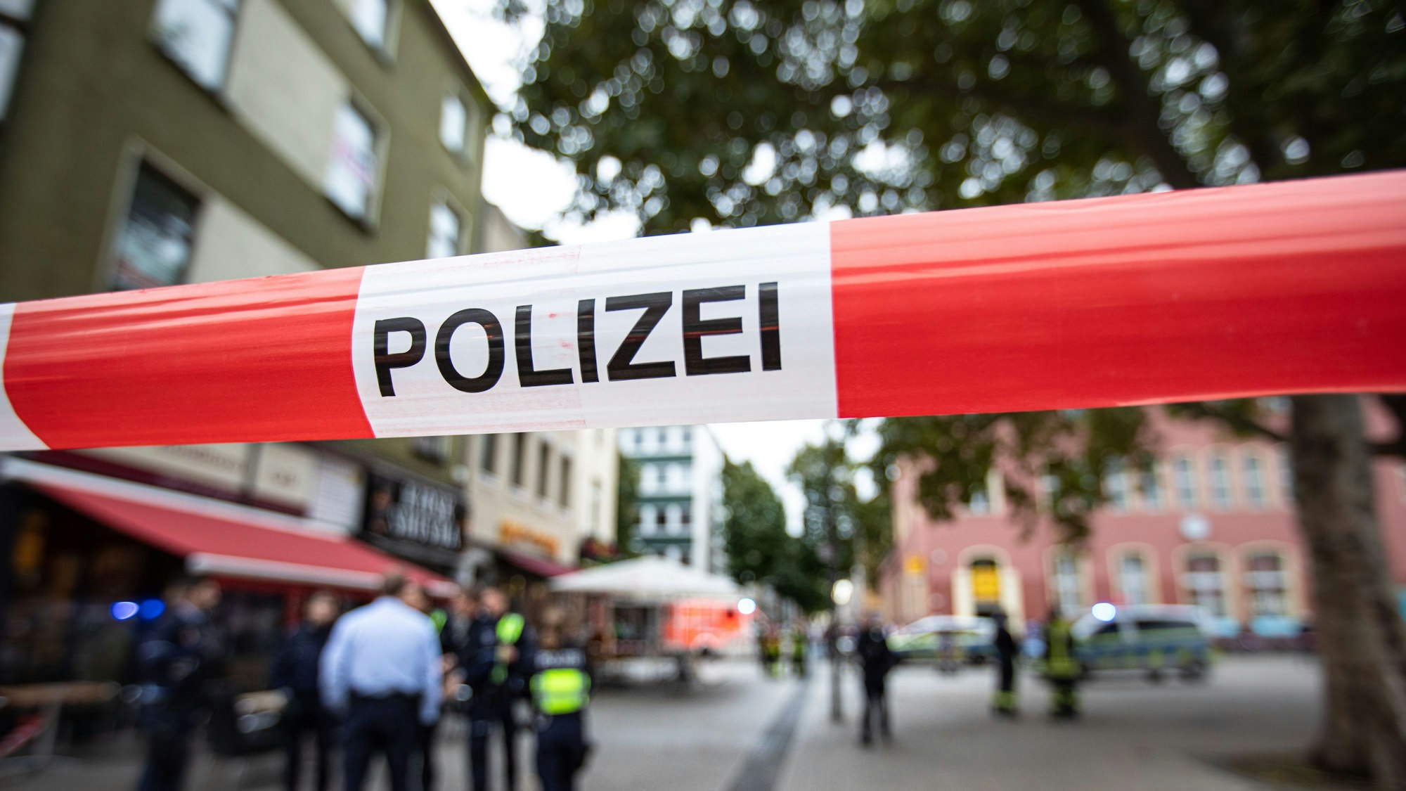 Polizisten und Polizistinnen stehen vor einem Imbiss.