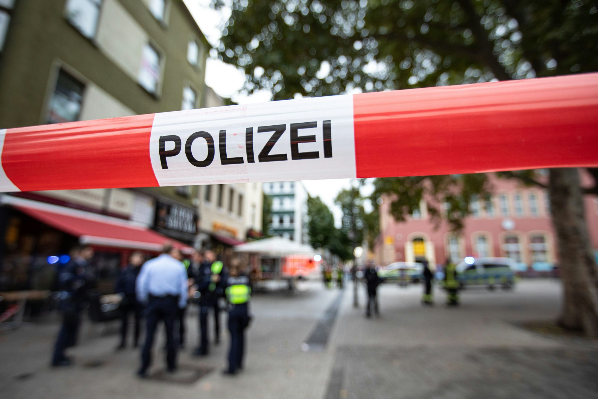 Polizeibeamte stehen bei einem Polizeieinsatz vor einem Fast-Food-Laden.