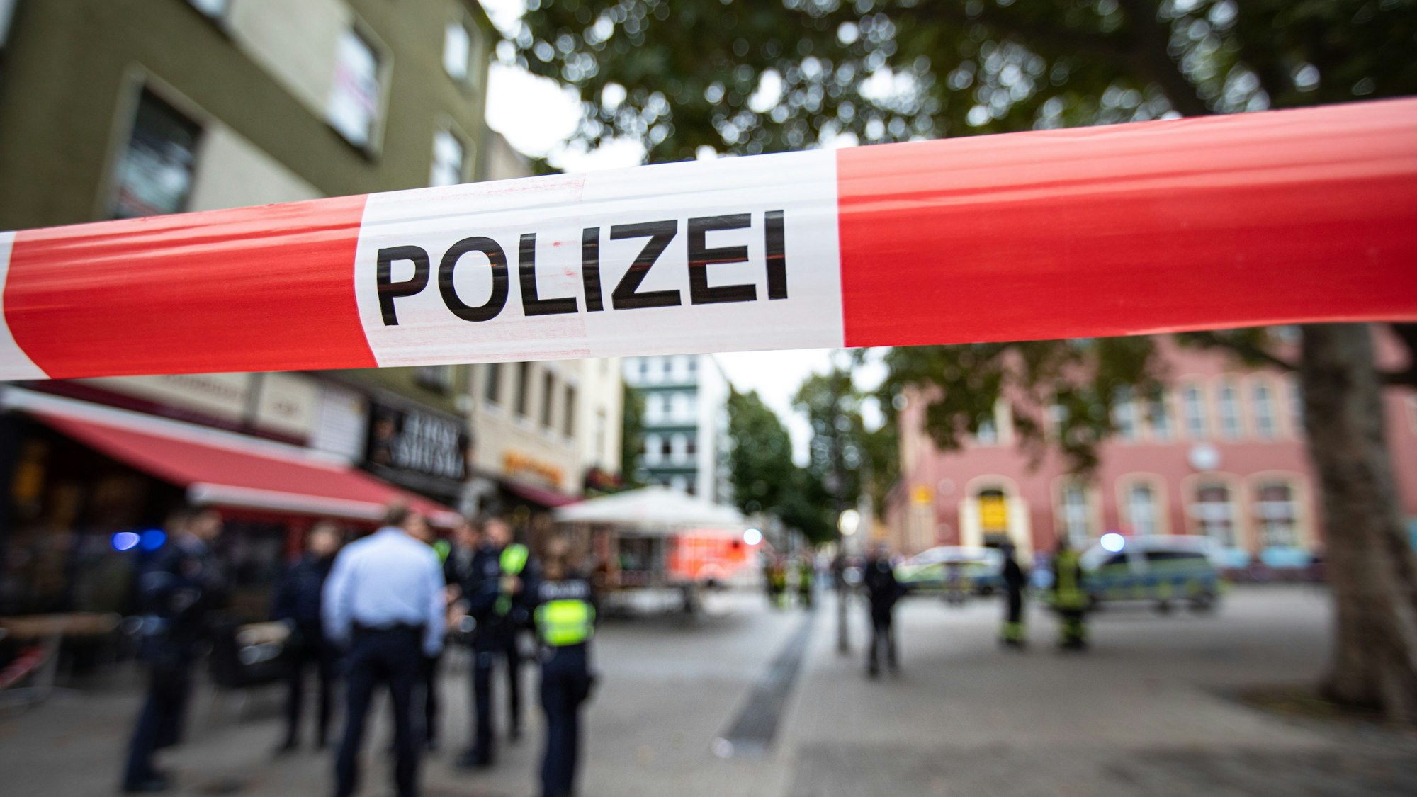 Polizeibeamte stehen bei einem Polizeieinsatz vor einem Fast-Food-Laden.