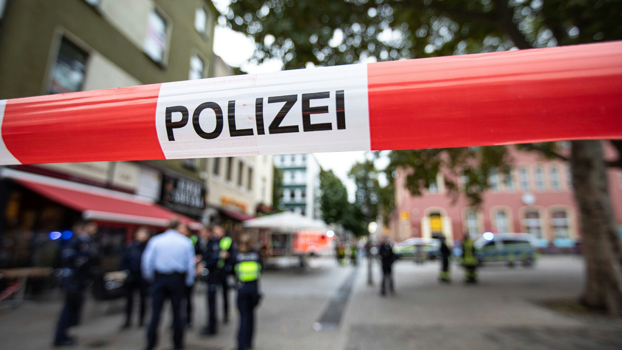 Absperrband der Polizei blockiert eine Straße in Köln während eines Polizeieinsatzes.