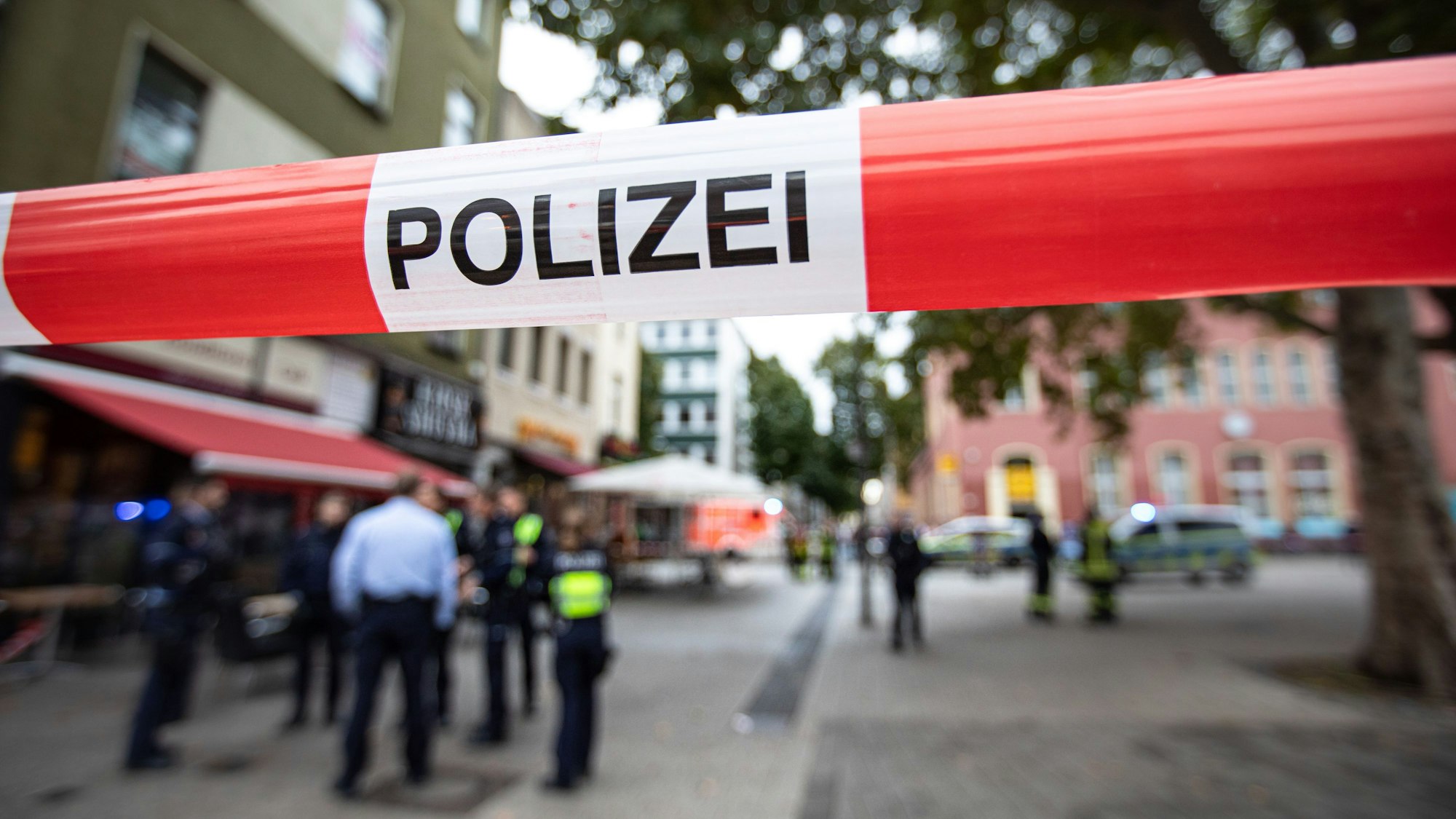 Polizeibeamte stehen bei einem Polizeieinsatz vor einem Fast-Food-Laden.