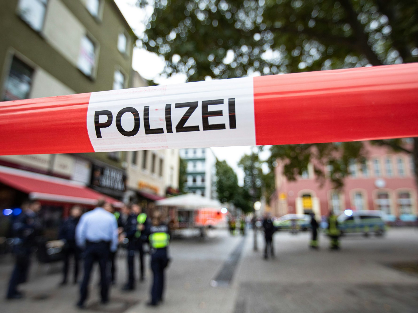Polizeibeamte stehen bei einem Polizeieinsatz vor einem Fast-Food-Laden.