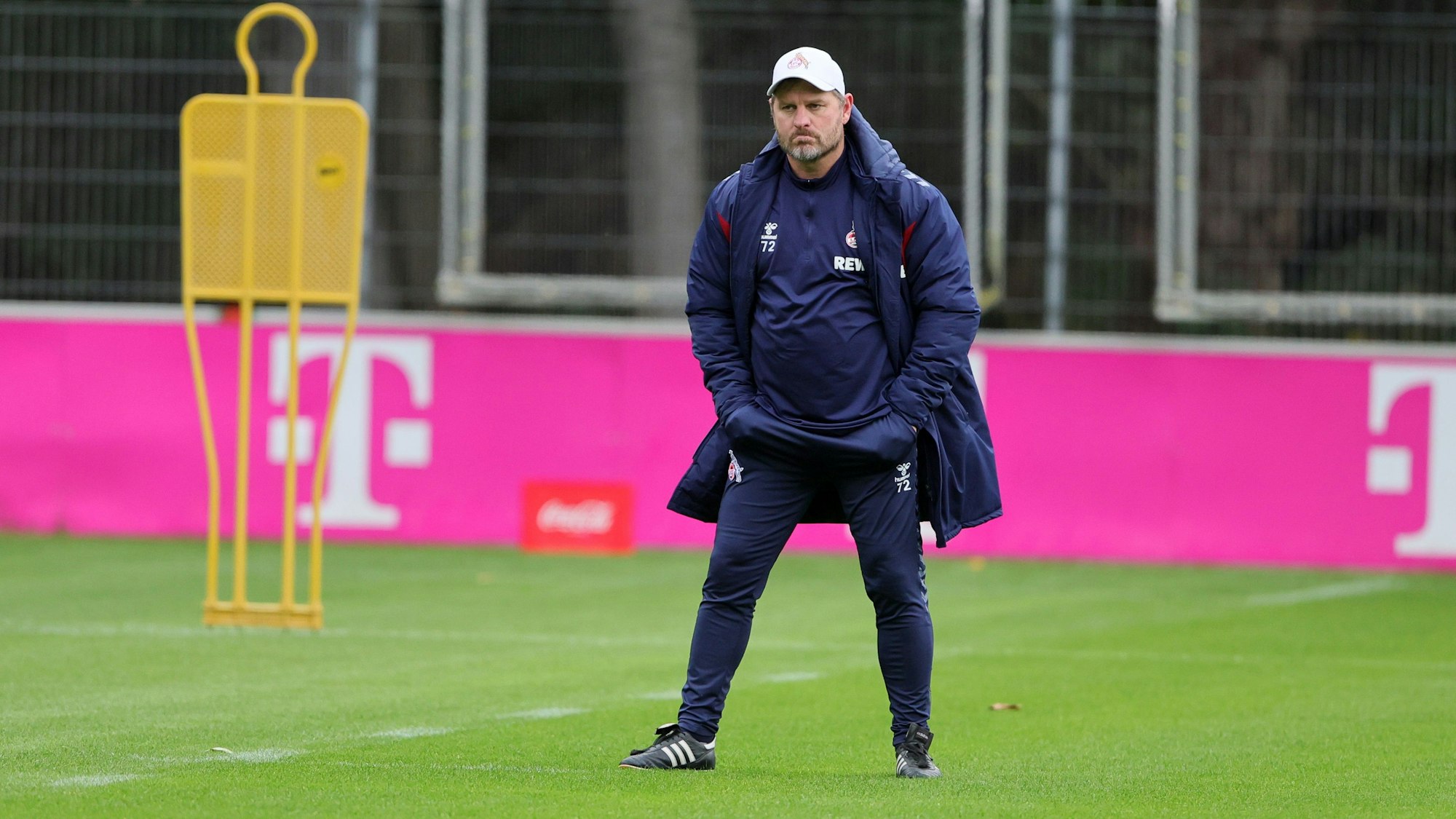 Steffen Baumgart steht mit Händen in den Hosentaschen auf dem Rasen am Geißbockheim.