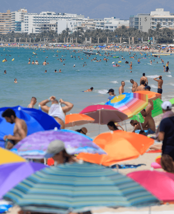 Urlauberinnen und Urlauber tummeln sich am Strand auf Mallorca.