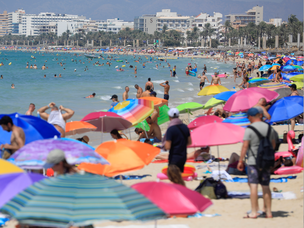 Urlauberinnen und Urlauber tummeln sich am Strand auf Mallorca.