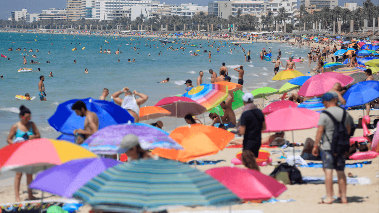 Urlauberinnen und Urlauber tummeln sich am Strand auf Mallorca.