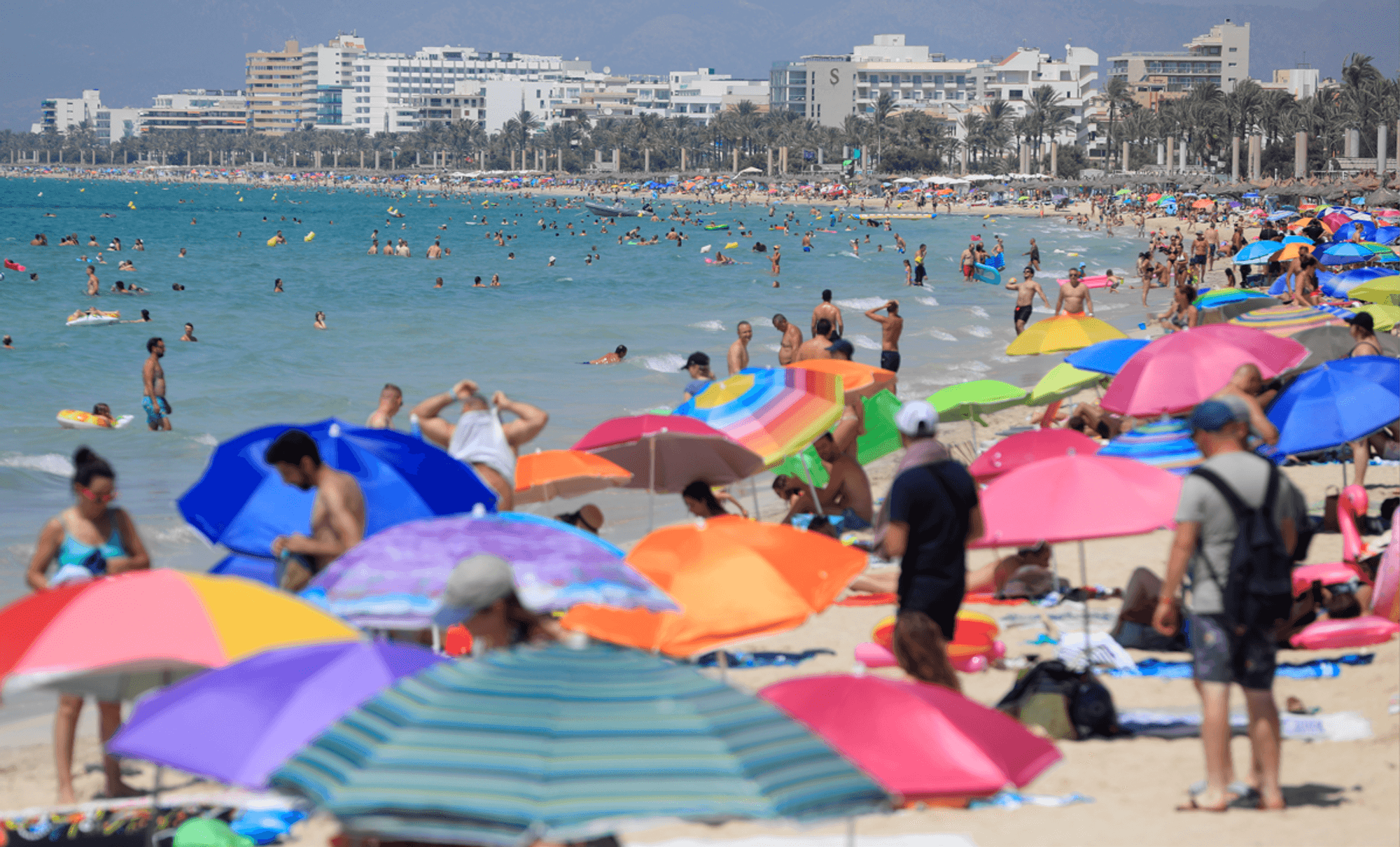 Menschen liegen am Strand auf Mallorca.