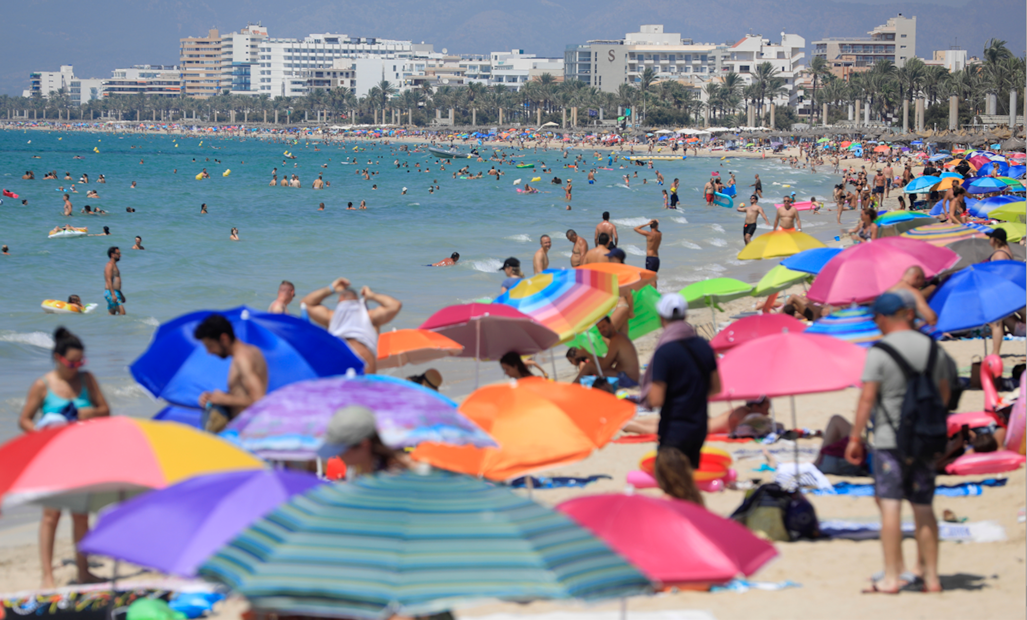 Menschen liegen am Strand auf Mallorca.