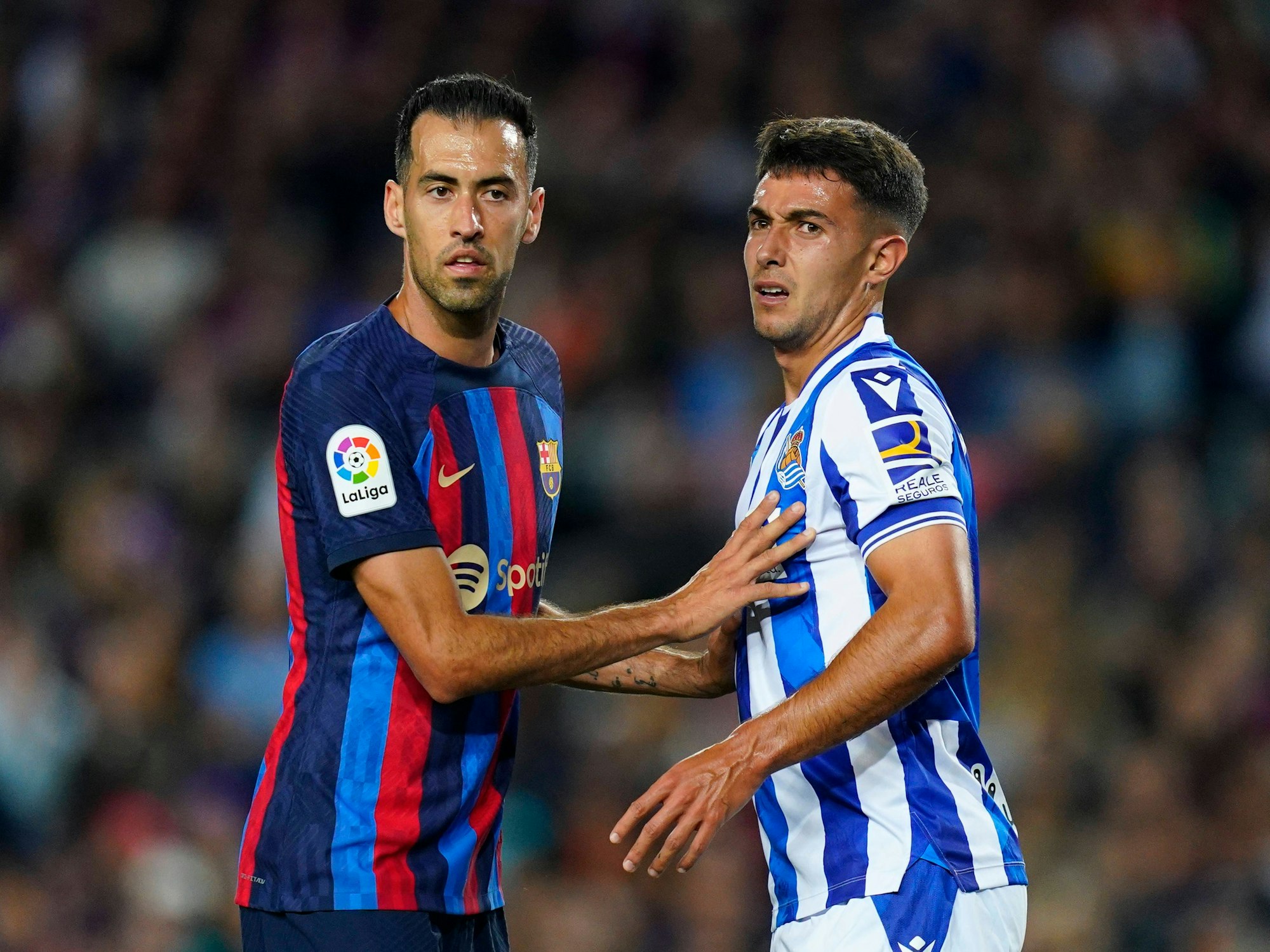 Sergio Busquets vom FC Barcelona und Martin Zubimendi von Real Sociedad warten auf den Ball.