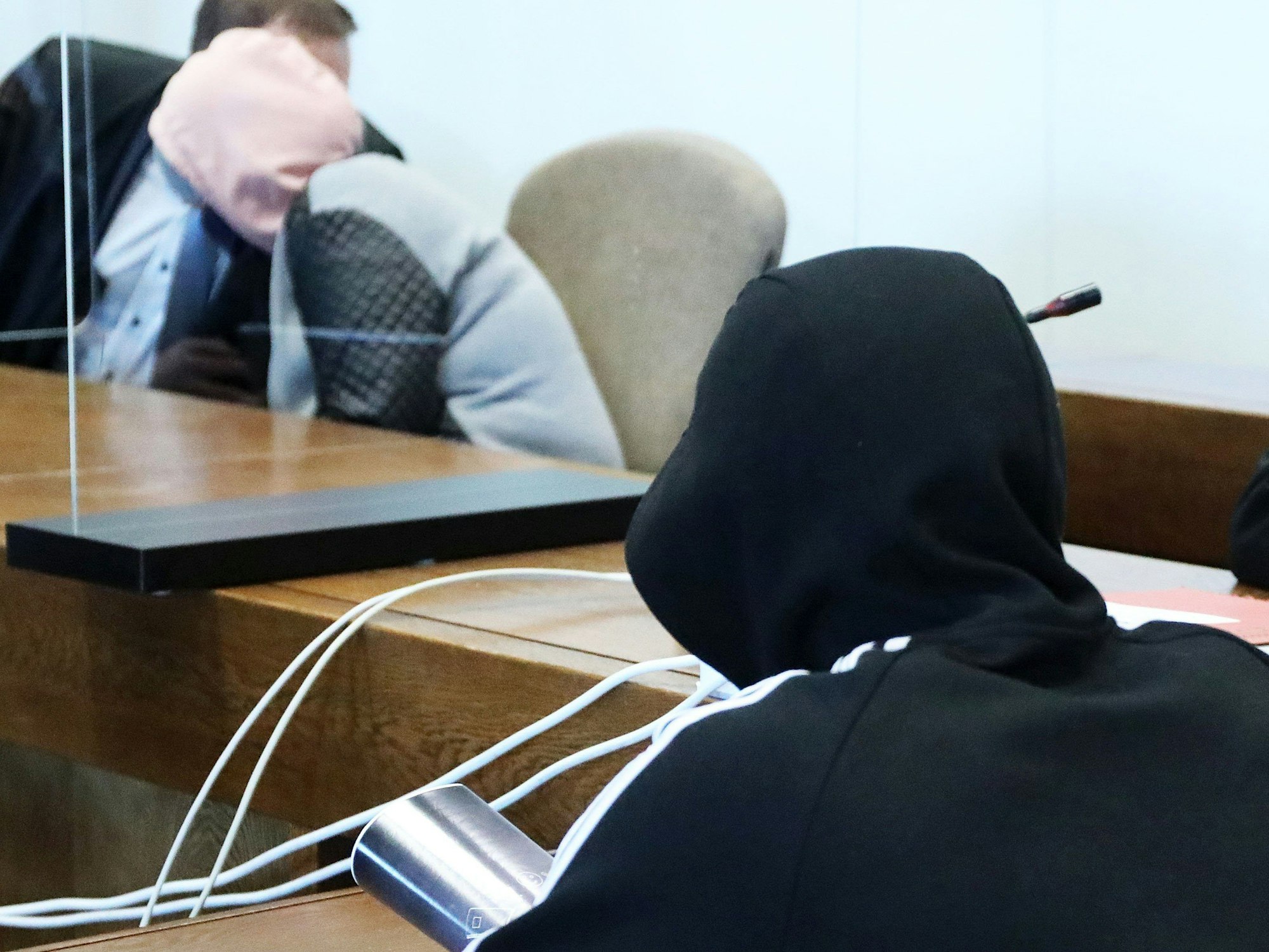 Die Mutter sitzt auf der Anklagebank und beugt sich zu einem Anwalt, ihr Ex-Freund sitzt ein paar Meter davor. Beide Angeklagten haben Kapuzen aufgesetzt.