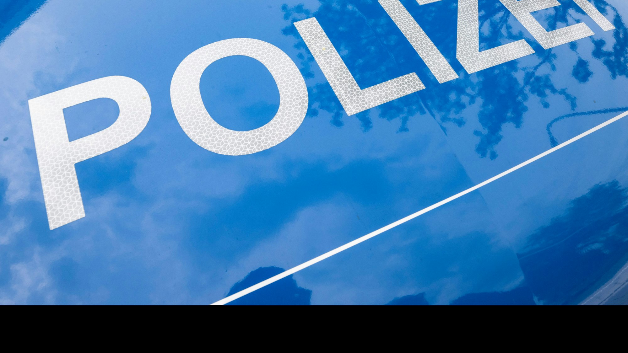 Der Schriftzug „Polizei“ ist auf einem Streifenwagen zu lesen.