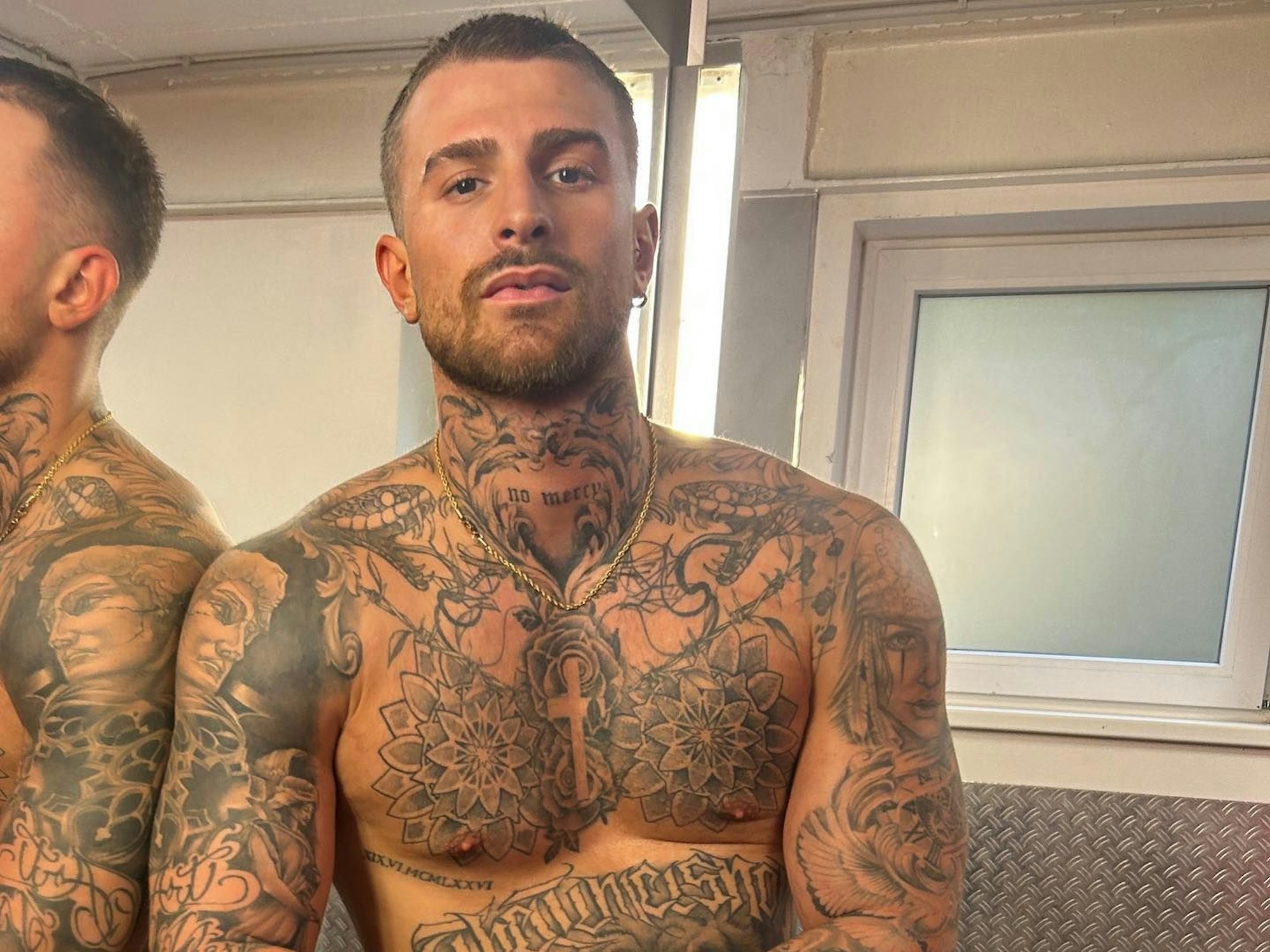 Gigi posiert oberkörperfrei.