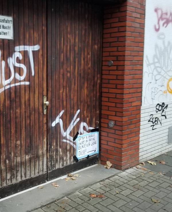Ein Garagentor mit einem Schild in der Ecke.
