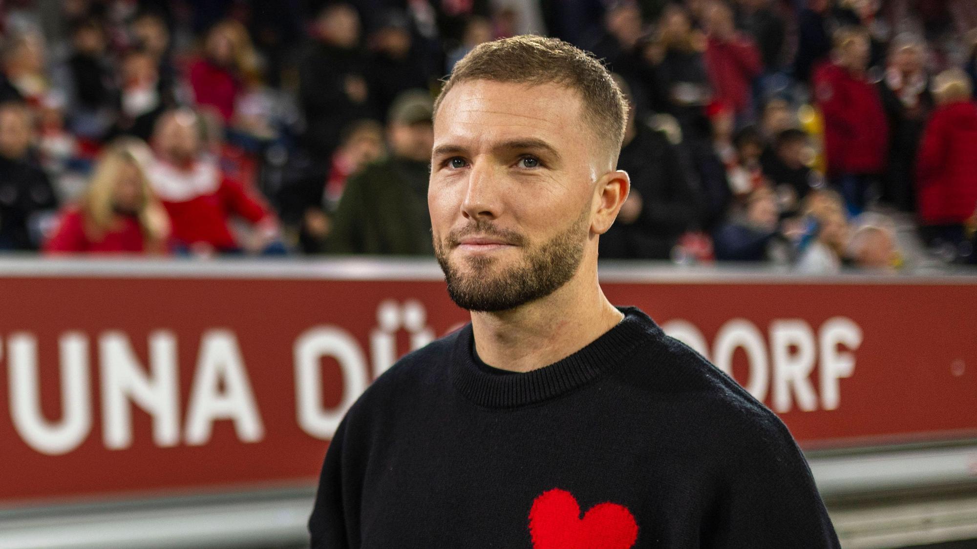 Fortuna Düsseldorfs Kapitän Andre Hoffmann steht beim Spiel gegen Wehen Wiesbaden in Zivil vor der Auswechselbank.