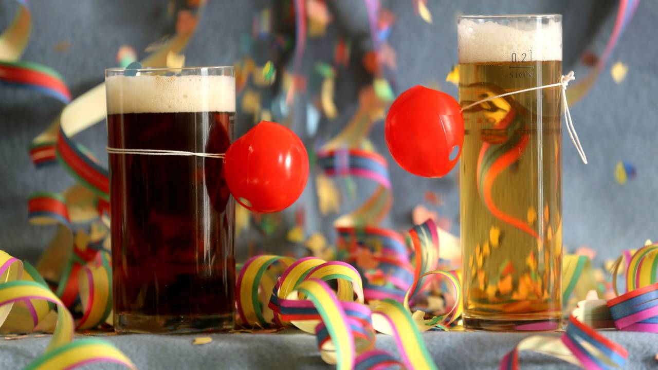 Hier zu sehen: Ein Altbier und ein Kölsch stehen, mit roten Pappnasen geschmückt, auf einem bunt dekorierten Tisch.