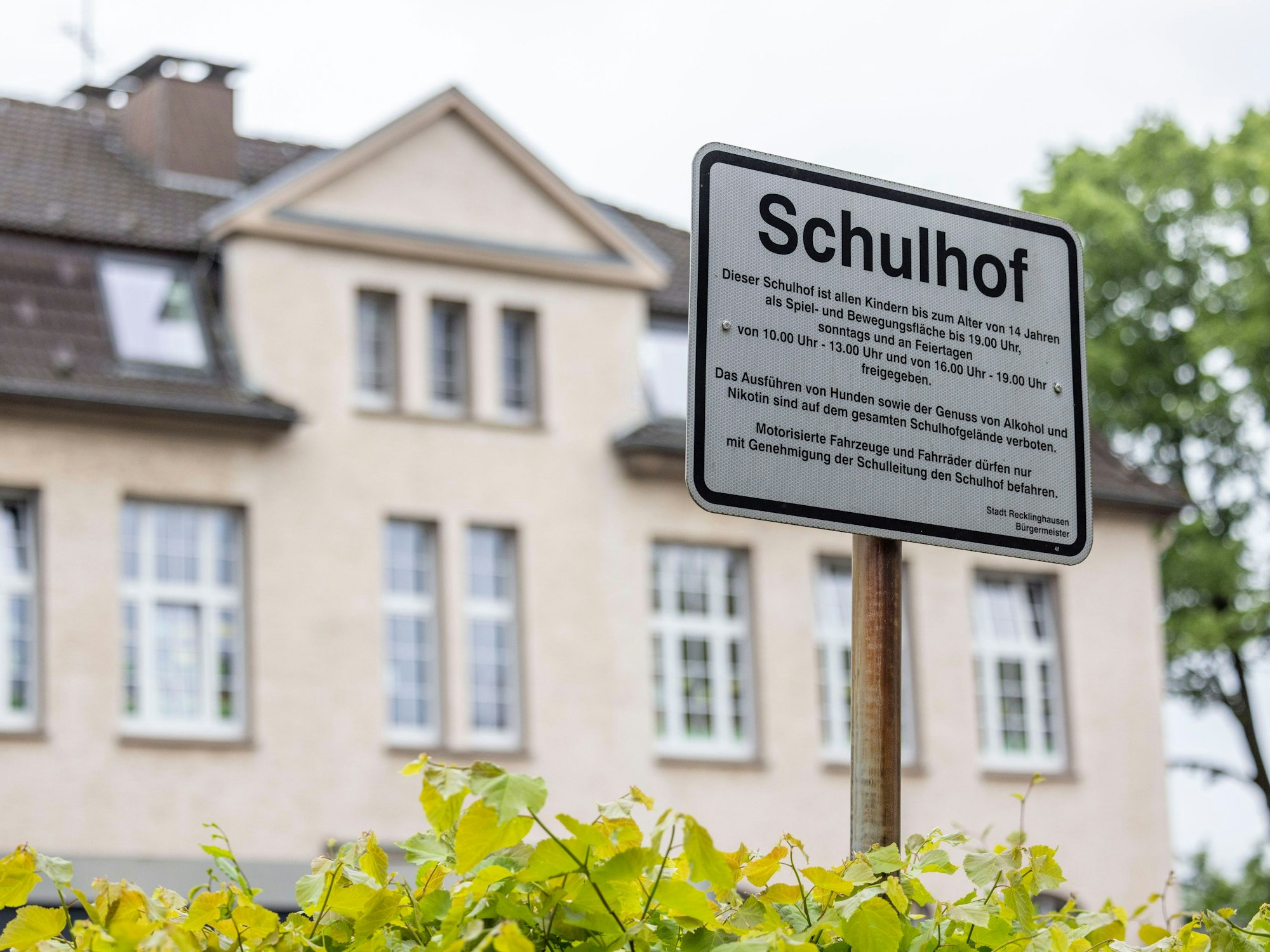 Regeln zum Aufenthalt auf dem Schulhof einer Grundschule sind vor dem Schulgebäude auf einem Schild zu lesen. Unter Ausschluss der Öffentlichkeit hat in Bochum am Freitag der Prozess um den gewaltsamen Tod einer 19-Jährigen begonnen.