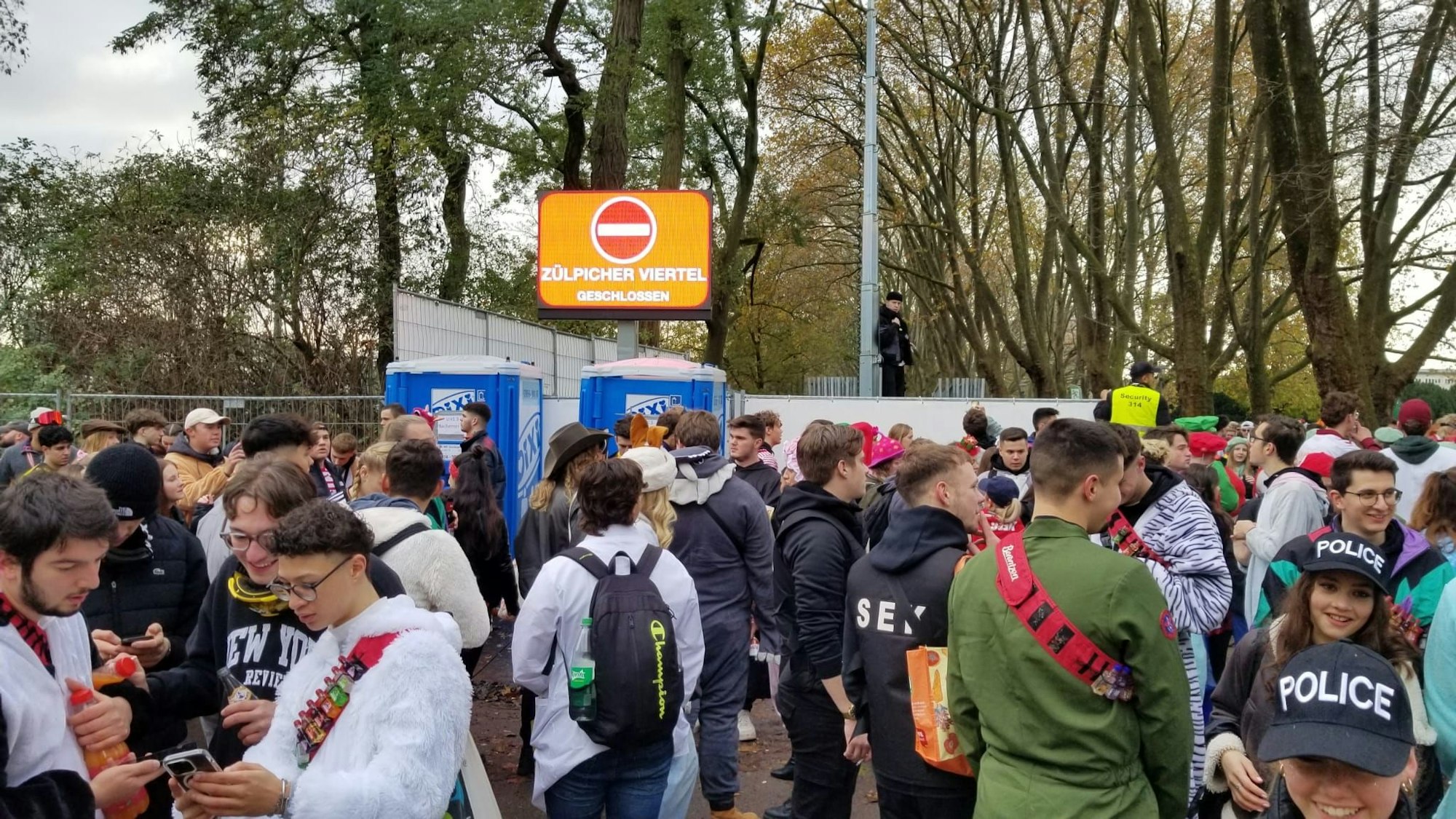 Viele Menschen wollen an der Uni-Mensa in Köln auf die Zülpicher Straße, aber die Eingänge sind dicht.