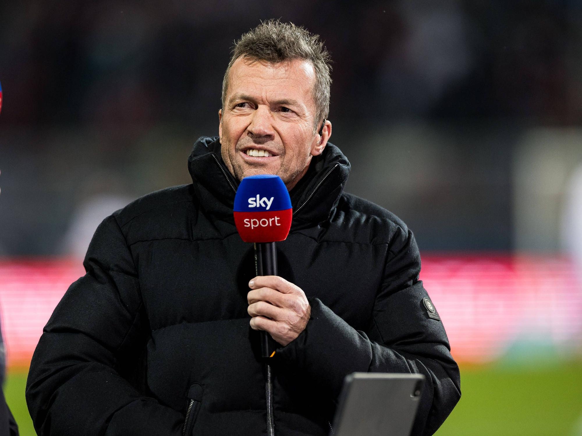 Lothar Matthäus hält sein Mikrofon.