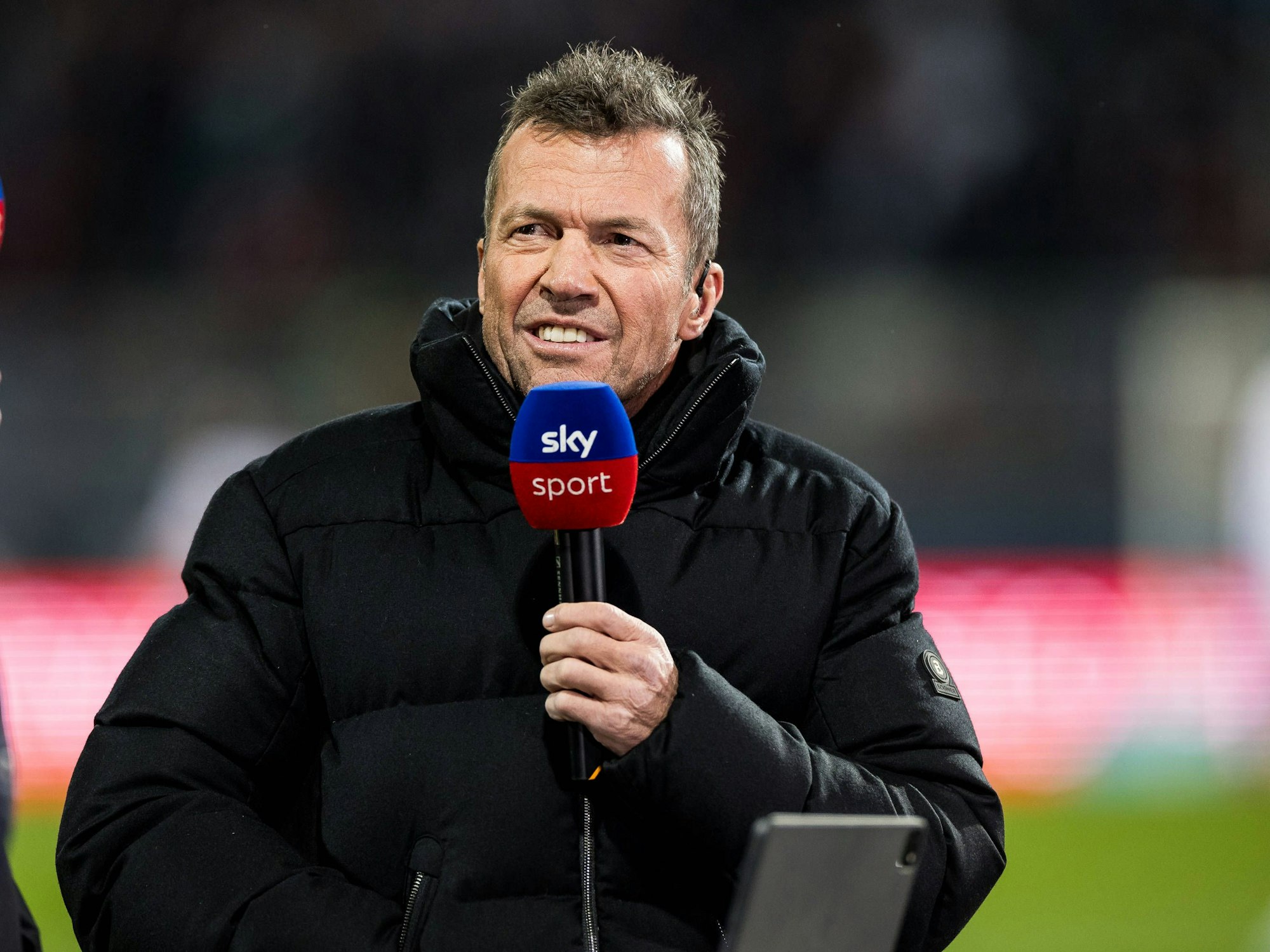 Lothar Matthäus hält sein Mikrofon.