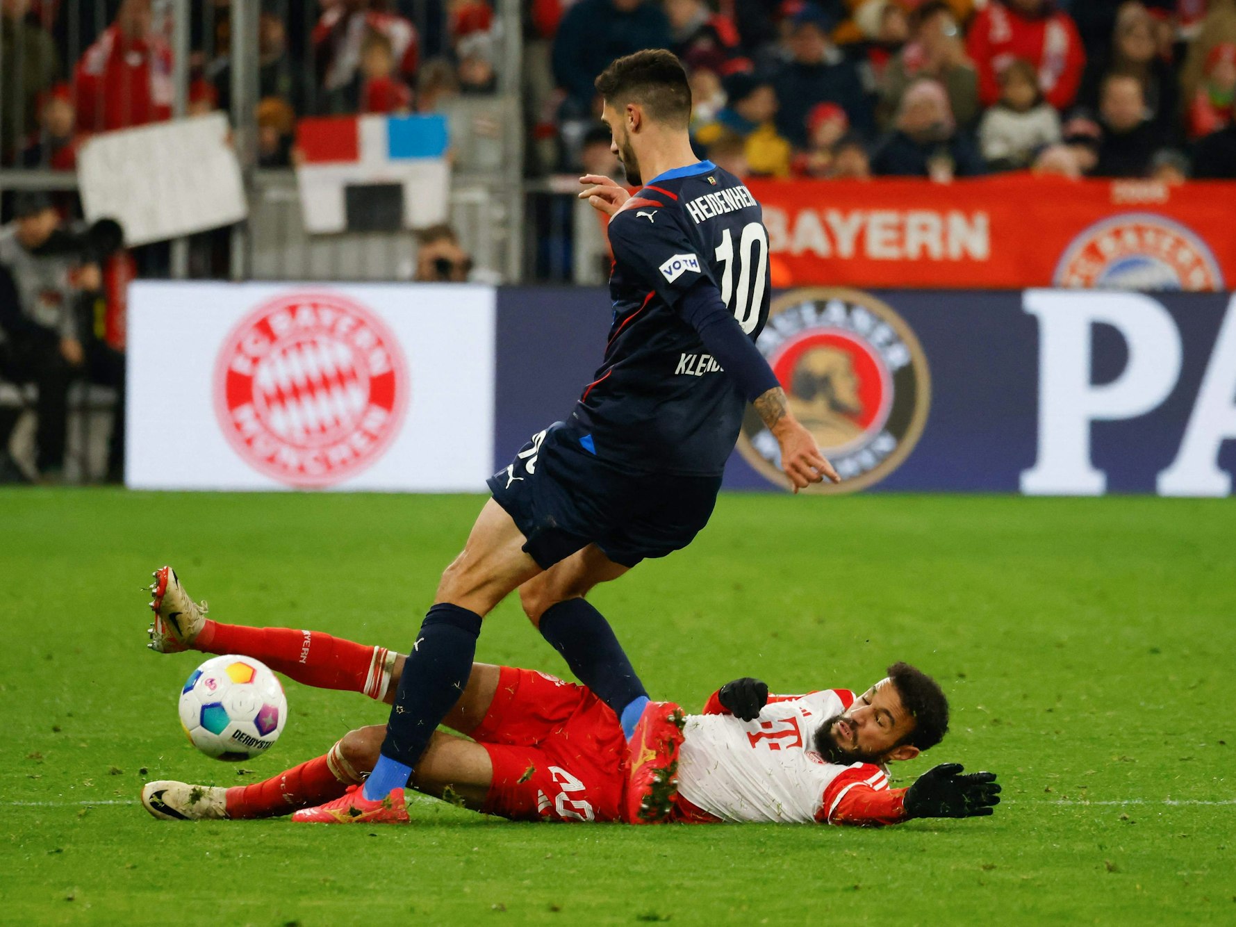 Noussair Mazraoui (FC Bayern) im Zweikampf mit Heidenheims Tim Kleindienst.