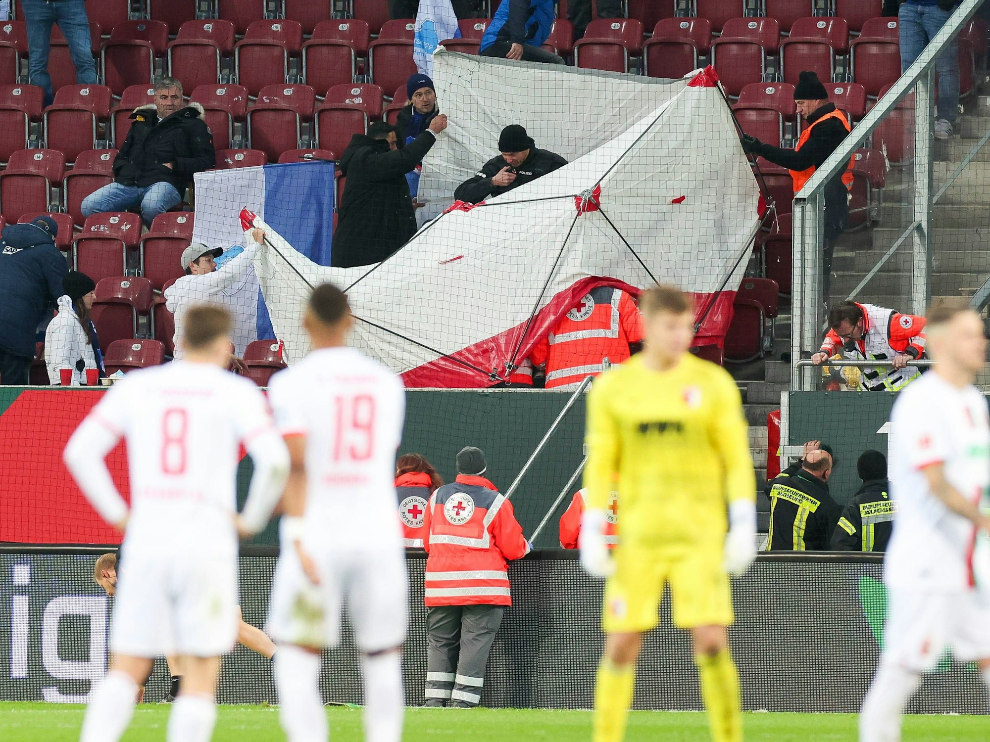 Der verletzte Fan wird hinter Sichtschutz versorgt.