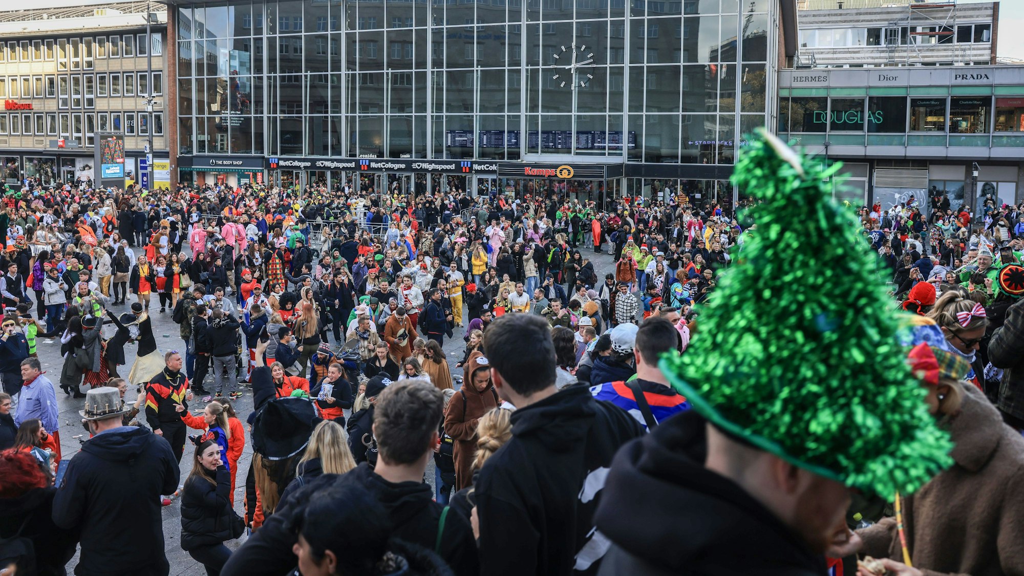 Hunderte Menschen stehen verkleidet vor dem Kölner Hauptbahnhof und feiern.