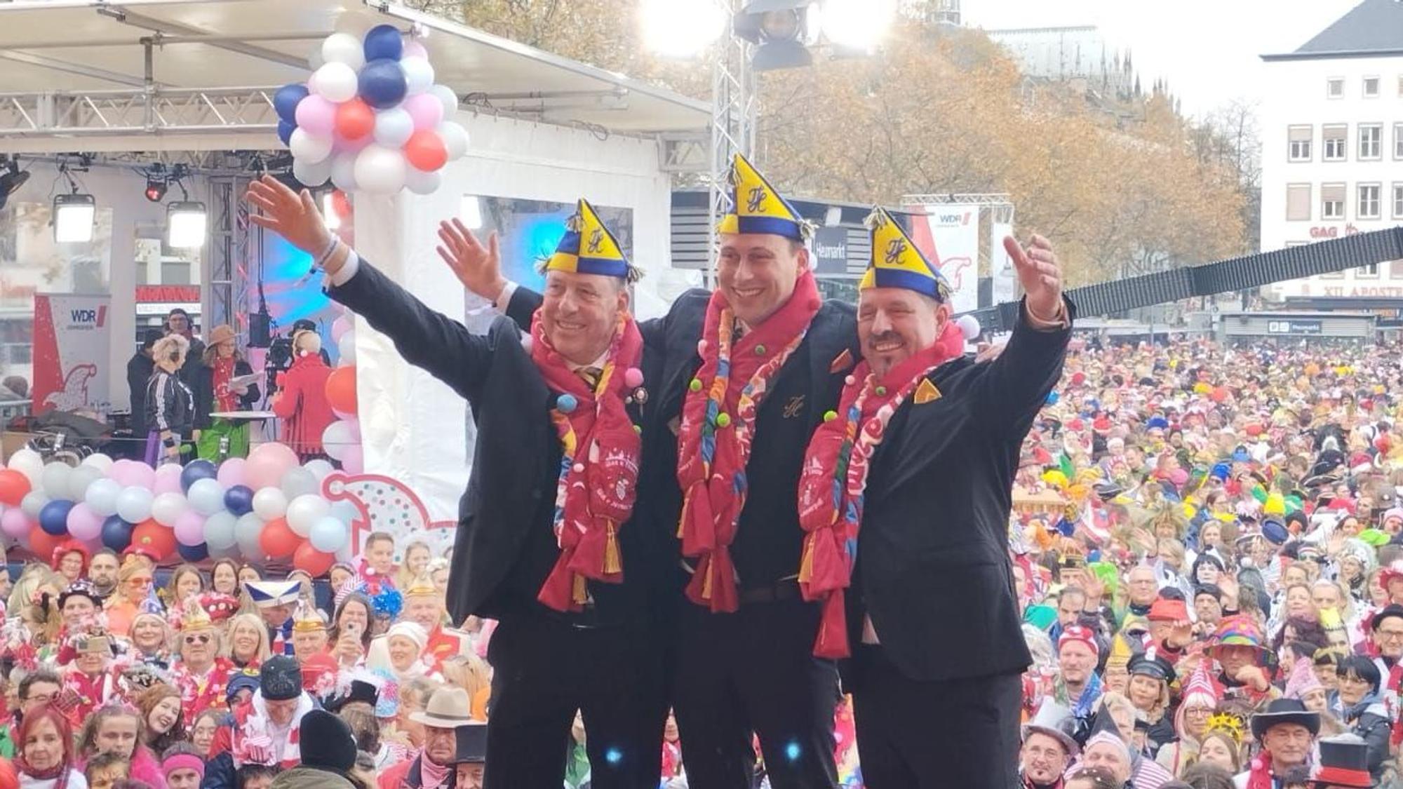 Das neue Dreigestirn steht vor der feiernden Menge am Heumarkt in Köln.