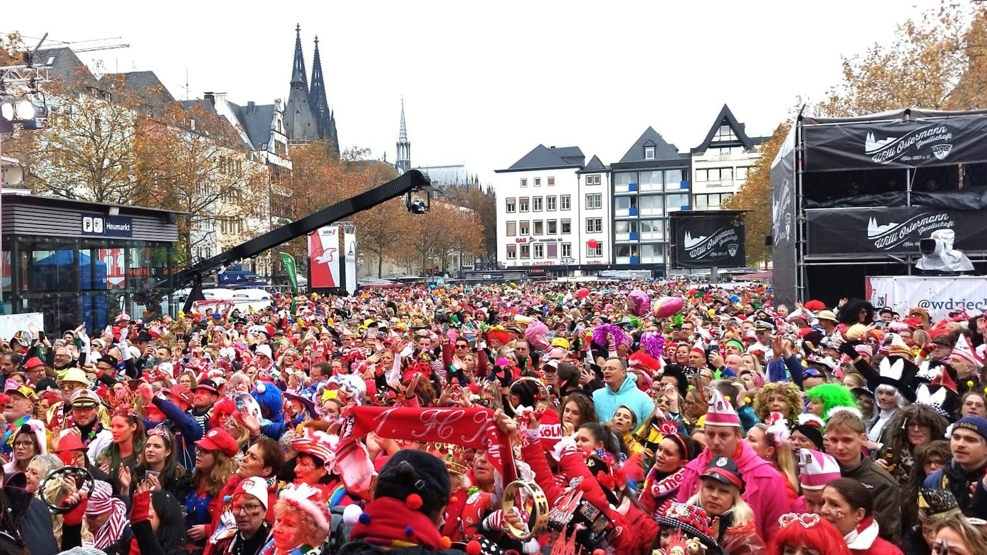 Viele Menschen stehen auf dem überfüllten Heumarkt in Köln, alles ist rot gekleidet.